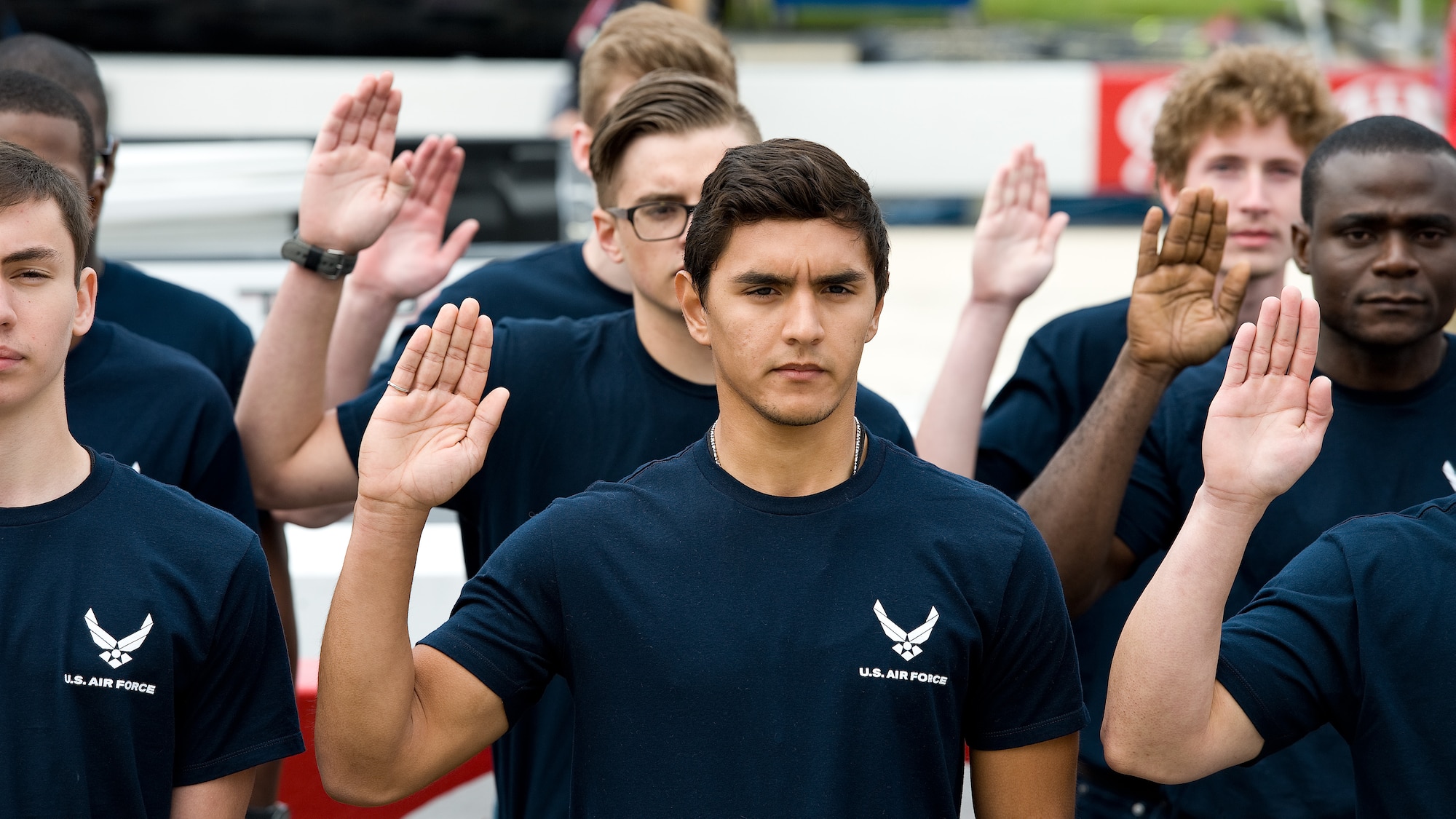 The newest U.S. Air Force recruits get ready to take the oath of enlistment during pre-race ceremonies prior to the AAA 400 Drive for Autism NASCAR Sprint Cup Series race May 15, 2016, at Dover International Speedway, Dover, Del. Brig. Gen. David E. Deputy, assistant adjutant general for air, Delaware National Guard, administered the oath to 26 enlistees that will be entering active duty or the Air National Guard. (U.S. Air Force photo/Roland Balik)