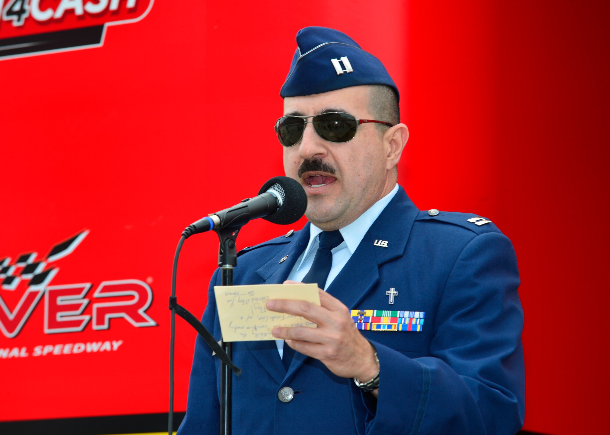 Chaplain (Capt.) Ruben Covos, 436th Airlift Wing chaplain, gives an invocation prior to the start of the “Ollie’s Bargain Outlet 200” NASCAR XFINITY Series Dash 4 Cash race May 14, 2016, at Dover International Speedway in Dover, Del. The colors were posted following the invocation by a U.S. Marine Corps honor guard team.  (U.S. Air Force photo/Senior Airman William Johnson)