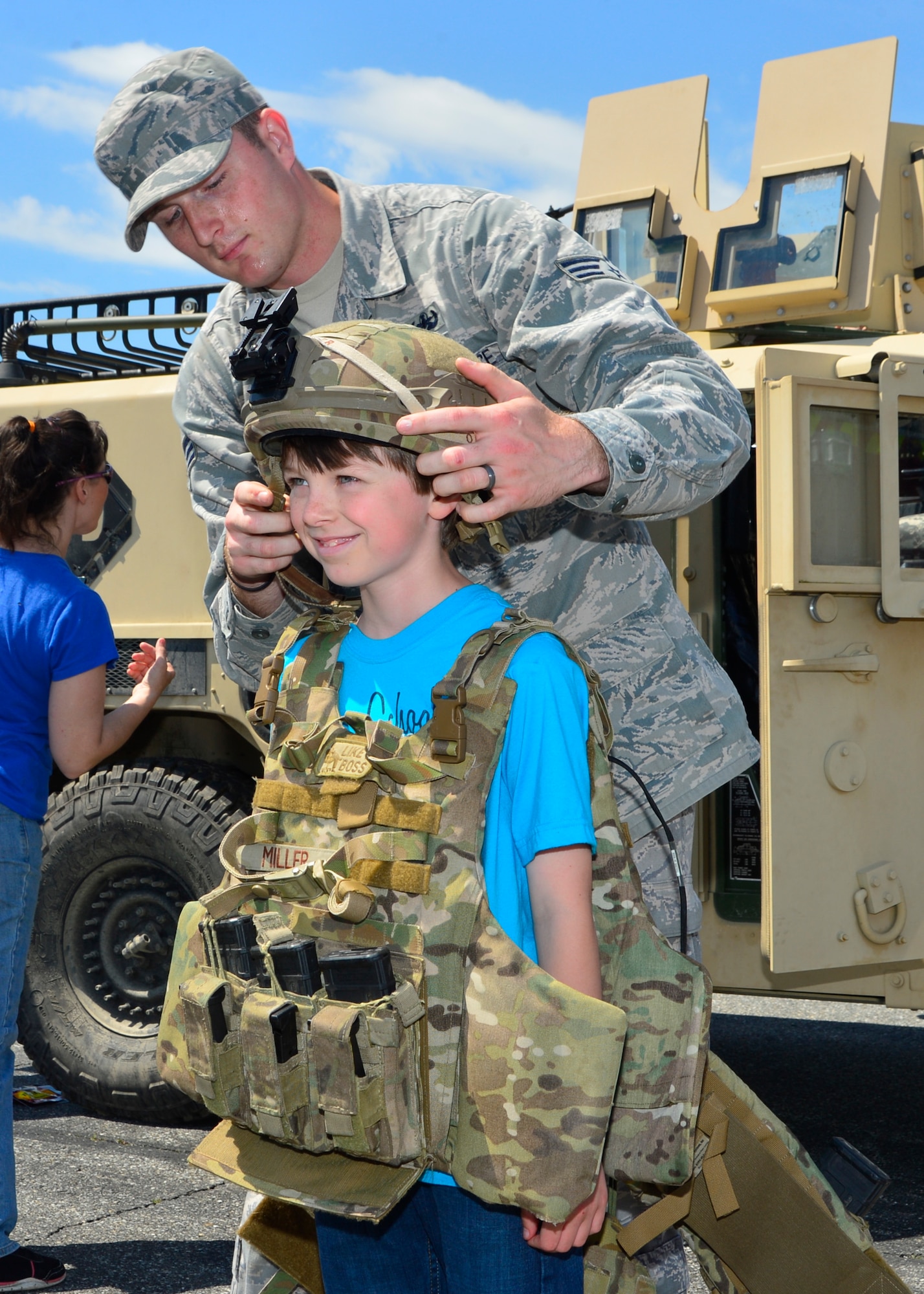 Senior Airman Joel Miller, 436th Civil Engineer Squadron Explosive Ordnance Disposal technician, outfits Robert Roof with battle-rattle inside the Monster Mile Youth Nation May 14, 2016, at Dover International Speedway in Dover, Del. Roof traveled with his family from Towanda, Pa., to watch the “Ollie’s Bargain Outlet 200” NASCAR XFINITY Series Dash 4 Cash race. (U.S. Air Force photo/Senior Airman William Johnson)