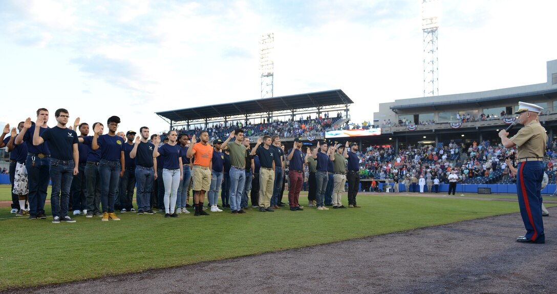 U.S. Marine Corps Col. Charles Dunne, U.S. Marine Corps Forces Command Headquarters and Service Battalion commanding officer, issues the oath of enlistment to Delayed Entry Program participants at the Norfolk Tides Armed Forces Night baseball game in Norfolk, Va., May 14, 2016. The event included a presentation of the colors by the U.S. Joint Service Color Guard and first pitches by Service members from each branch of the Armed Forces. (U.S. Air Force photo by Staff Sgt. Teresa J. Cleveland)