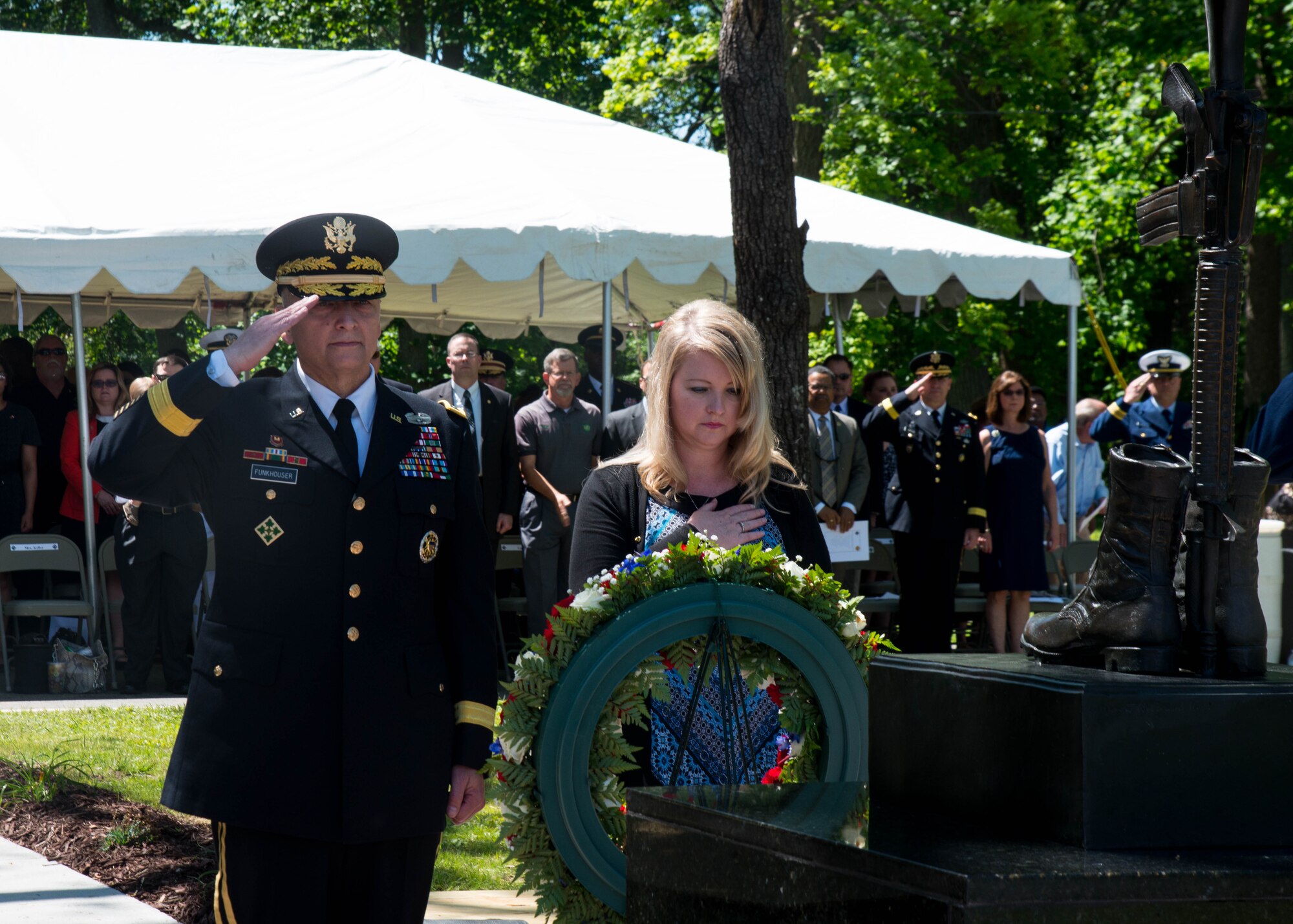 U.S. Army Maj. Gen. Anthony Funkhouser, commander of the U.S. Army Center for Initial Military Training, and Jackie Keller render respect during the Bronze Cross memorial unveiling ceremony in Magnolia Park at Fort Eustis, Va., May 14, 2016. Keller’s brother Spc. Ramyond Faulstitch Jr., was the first Soldier from Fort Eustis to be killed in Operation Iraqi Freedom.  (U.S. Air Force photo by Staff Sgt. J.D. Strong II)