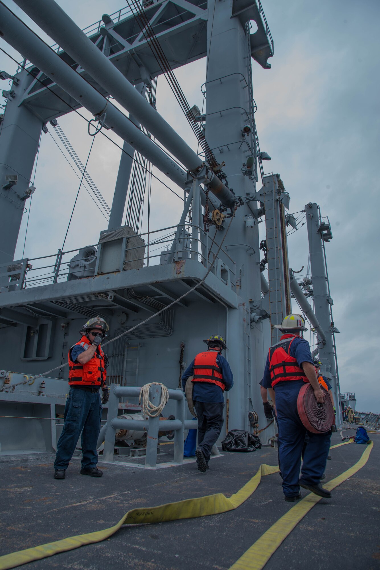 Students of the 25th Annual Hampton Roads Marine Firefighting School maritime incident response exercise carry hoses to the bow of the Cape Avinof at Fort Eustis, Va., May 13, 2016. Military and civilian fire fighters from around the world participated in the five-day school, which ended with the incident response exercise.  (U.S. Air Force photo by Staff Sgt. J.D. Strong II)