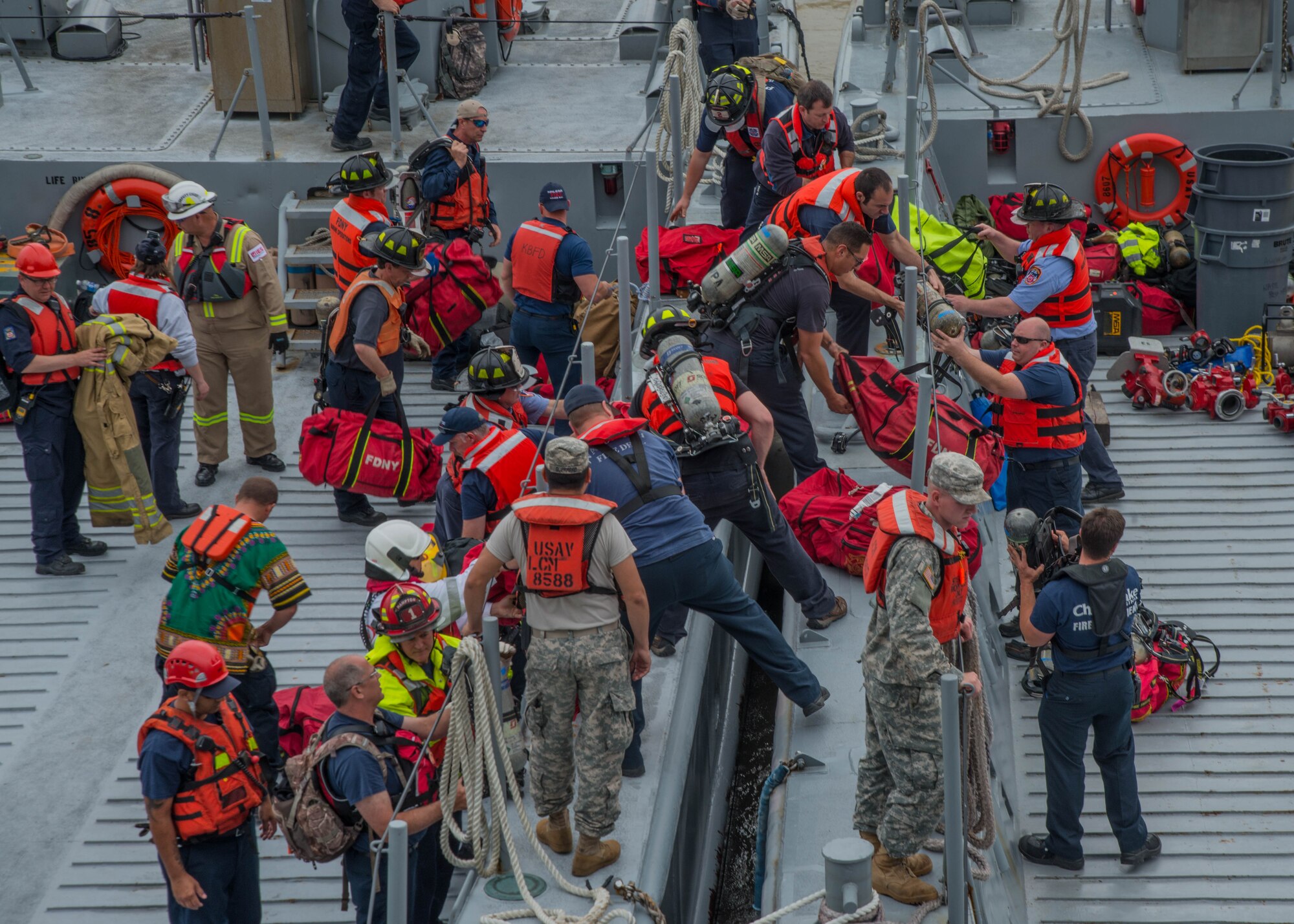 U.S. Soldiers assigned to the 7th Transportation Brigade assist students participating in the 25th Annual Hampton Roads Marine Firefighting School maritime incident response exercise with moving equipment at Fort Eustis, Va., May 13, 2016. The exercise involved crews from different agencies around the world working together to accomplish rescues during a simulated maritime fire. (U.S. Air Force photo by Staff Sgt. J.D. Strong II)