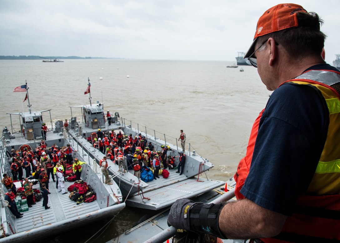 A participant of the 25th Annual Hampton Roads Marine Firefighting School maritime incident response exercise overlooks the arrival of fire fighters to the Cape Avinof at Fort Eustis, Va., May 13, 2016. During the five-day school, civilian, military and international fire fighters, learned of new maritime firefighting methods and exchanged techniques with one another.  (U.S. Air Force photo by Staff Sgt. J.D. Strong II)