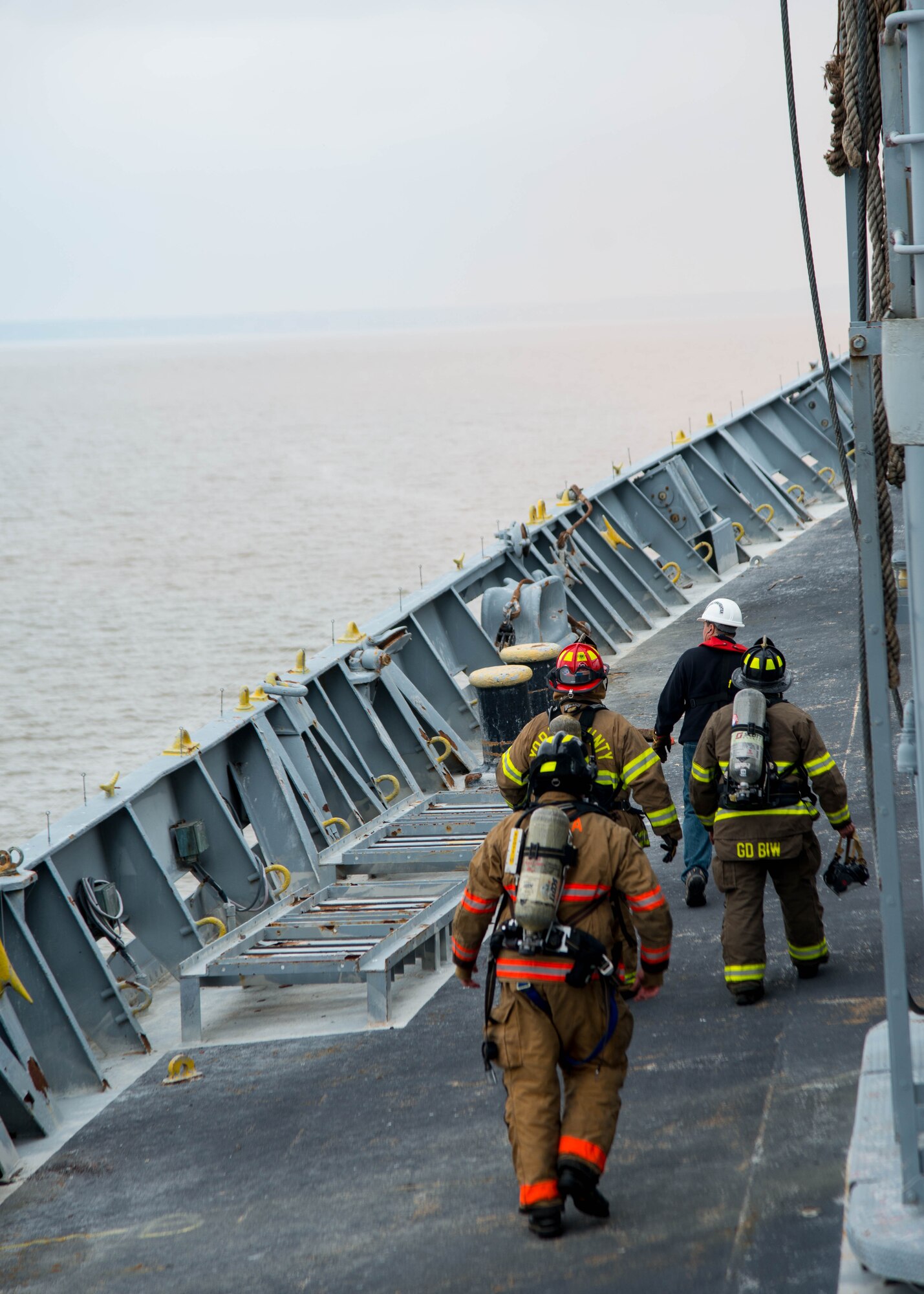 Students walk to the bow of the Cape Avinof during the 25th Annual Hampton Roads Marine Firefighting School maritime incident response exercise at Fort Eustis, Va., May 13, 2016. This is the 25th year of the event, giving fire fighters who have little to no experience with maritime response the opportunity to learn established incident response and control tactics. (U.S. Air Force photo by Staff Sgt. J.D. Strong II)