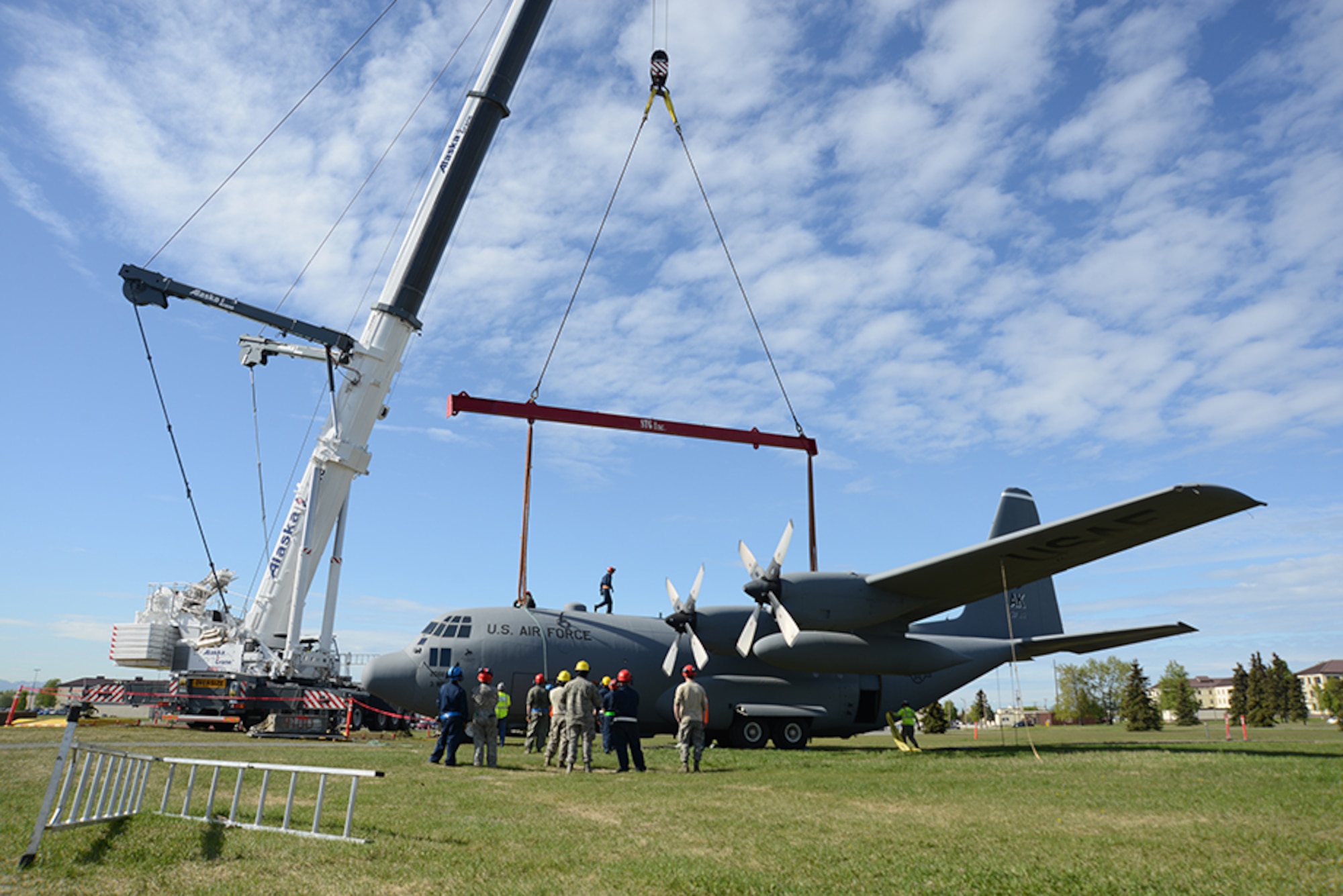A crane lifts a C-130 Hercules toward a pedestal at Heritage Park for display at Joint Base Elmendorf-Richardson, Alaska, May 12, 2016. Anchorage Cranes was contracted by the Air Force to lift the C-130 Hercules and F-102 onto the pedestal, finishing the post-refurbishment move back to Heritage Park. (U.S. Air Force photo by Airman 1st Class Christopher R. Morales)