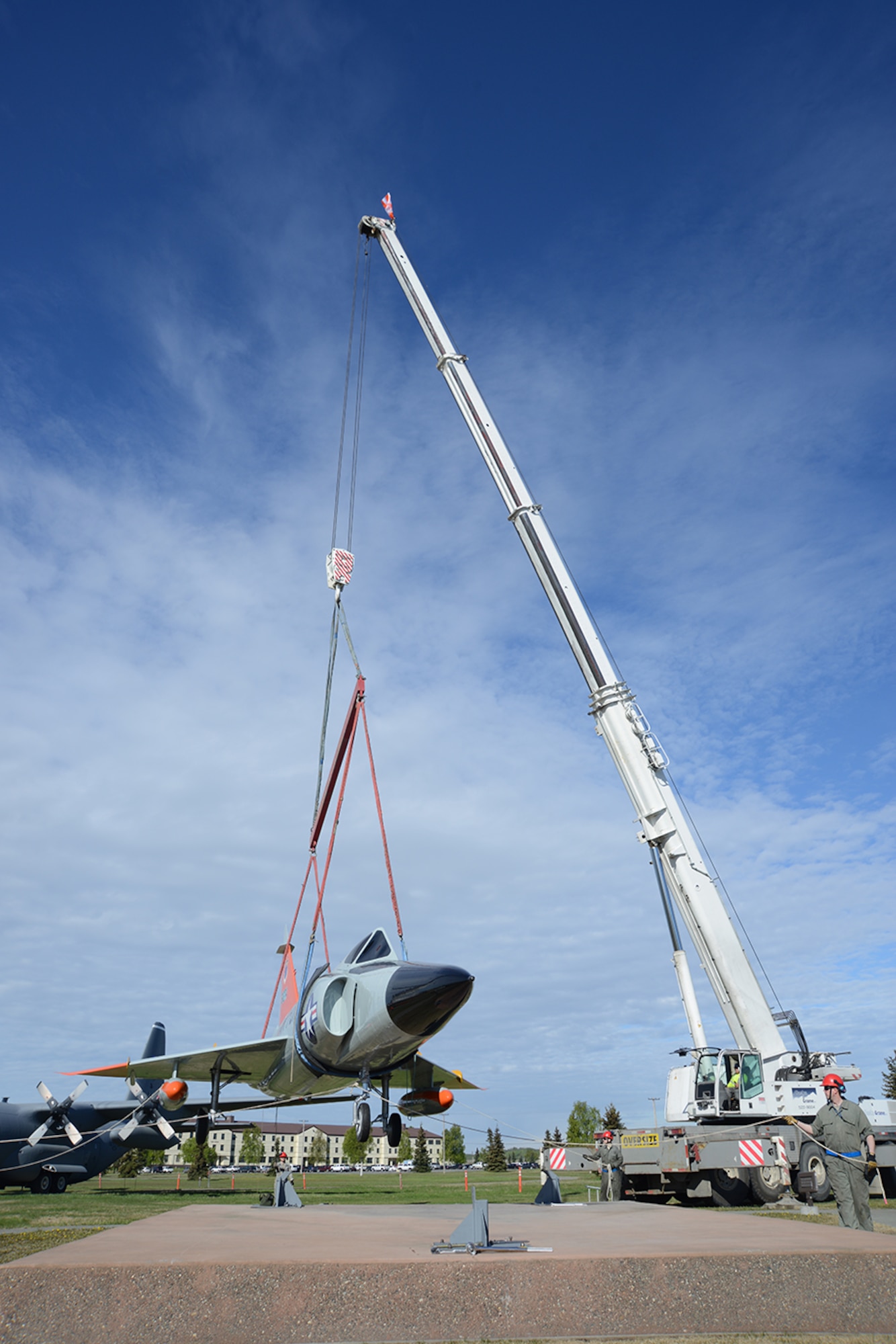A crane lifts an F-102 Delta Dagger toward a pedestal at Heritage Park for display at Joint Base Elmendorf-Richardson, Alaska, May 12, 2016. Anchorage Cranes was contracted by the Air Force to lift the C-130 Hercules and F-102 onto the pedestals, finishing the post-refurbishment move back to Heritage Park. (U.S. Air Force photo by Airman 1st Class Christopher R. Morales)