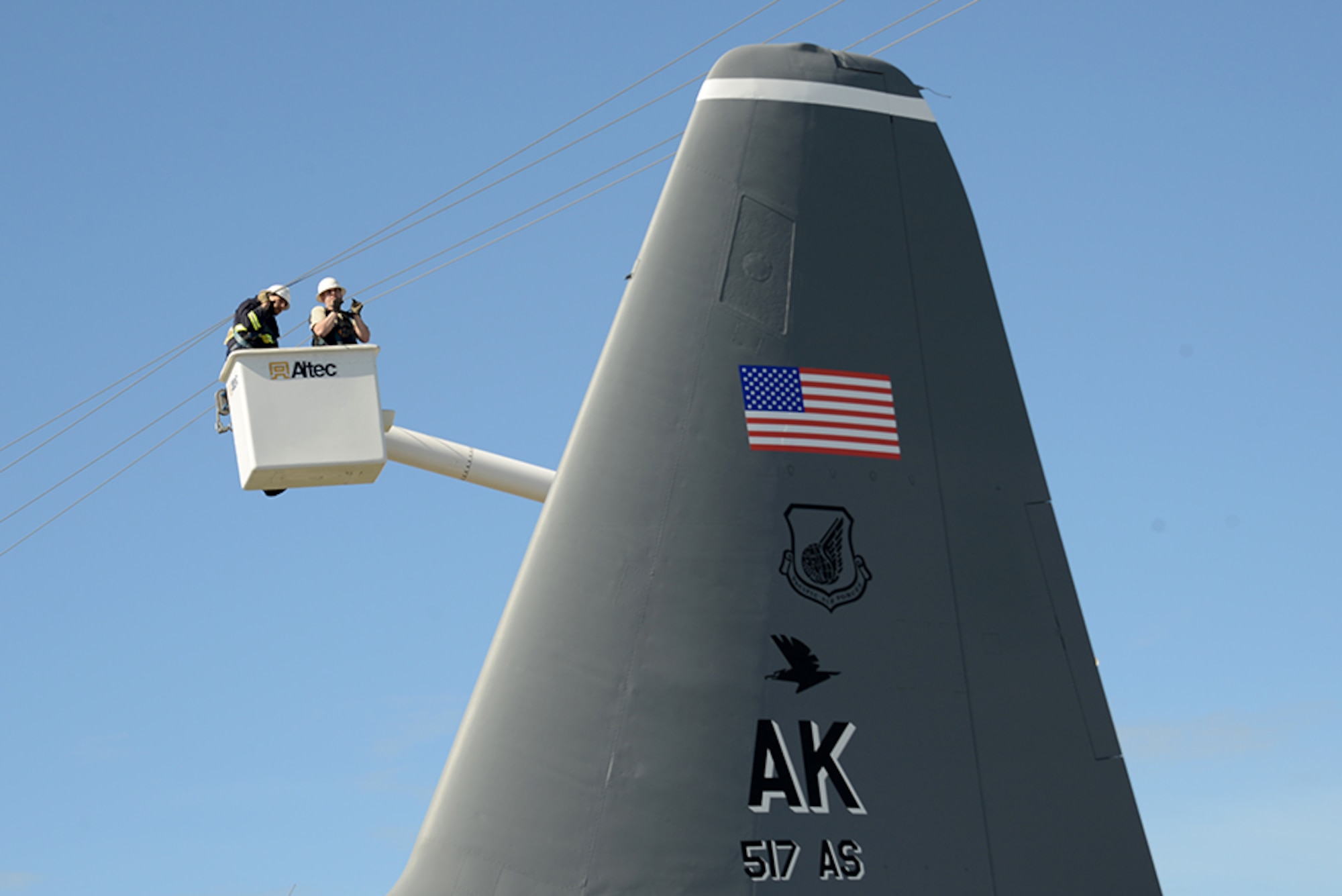 General Communication Inc. workers lift the upper most telephone wires to make room for the C-130 Hercule’s tail as it is moved back to Heritage Park after being refurbished at Joint Base Elmendorf-Richardson, Alaska, May 7, 2016. Aircraft are refurbished and put on display at Heritage Park to show the base populace retired aircraft which have accomplished the Air Force mission. (U.S. Air Force photo by Airman 1st Class Christopher R. Morales)