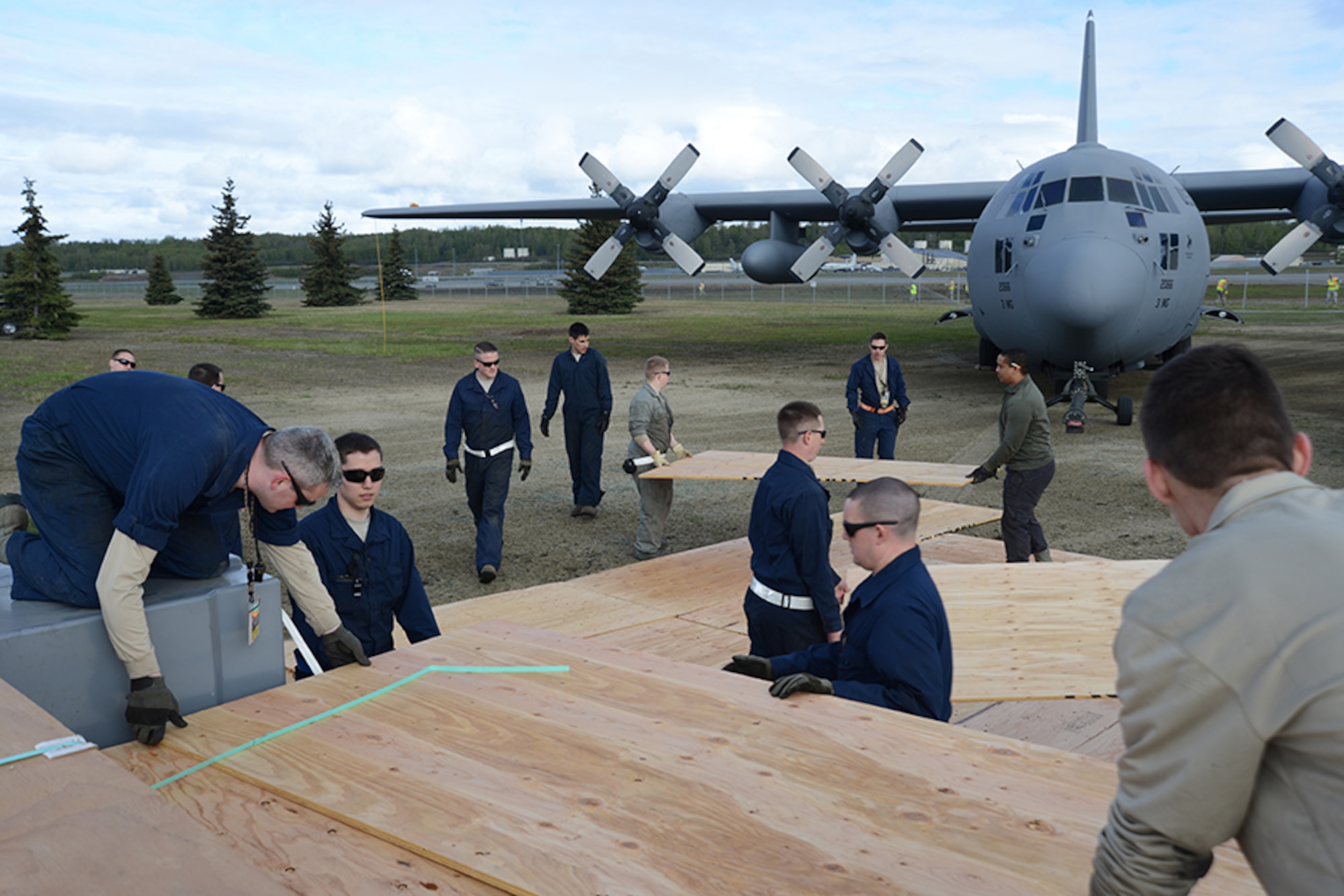 3rd Maintenance Squadron Airmen lay down plywood so the aircraft do not sink into the soft ground during the C-130 Hercules and F-102 Delta Dagger move back to Heritage Park, Joint Base Elmendorf-Richardson, Alaska, May 7, 2016. The F-102 weighs more than 19,000 pounds and the C-130 weighs more than 75,000 pounds so the 3rd MXS implemented a few safety precautions. (U.S. Air Force photo by Airman 1st Class Christopher R. Morales)