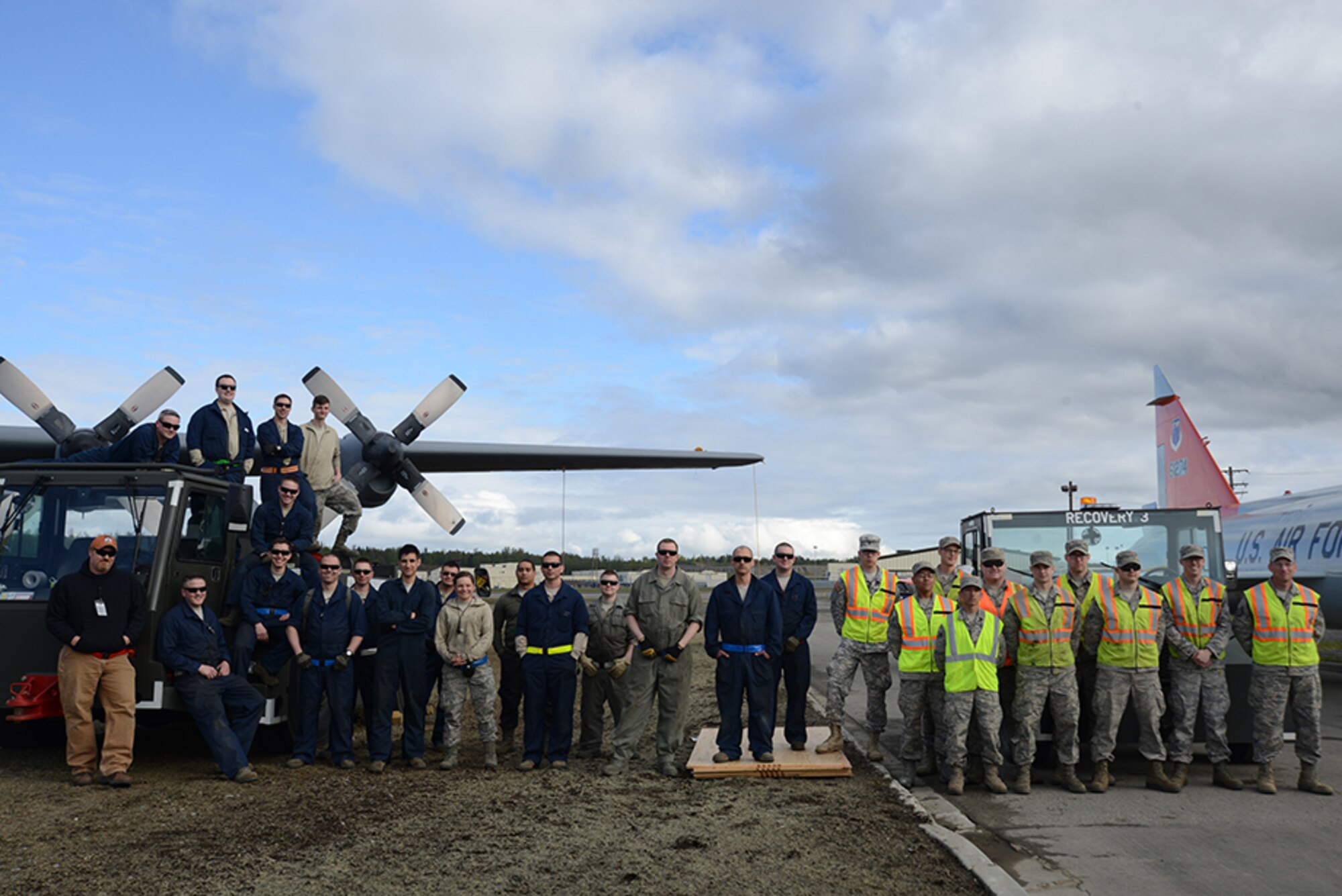 Members of the 3rd Maintenance Squadron pose for a group shot during the C-130 Hercules and F-102 Delta Dagger move back to Heritage Park at Joint Base Elmendorf-Richardson, Alaska, May 7, 2016. The aircraft began refurbishment in February and were lifted by a heavy-duty crane May 12 to be returned to its display position. (U.S. Air Force photo by Airman 1st Class Christopher R. Morales)