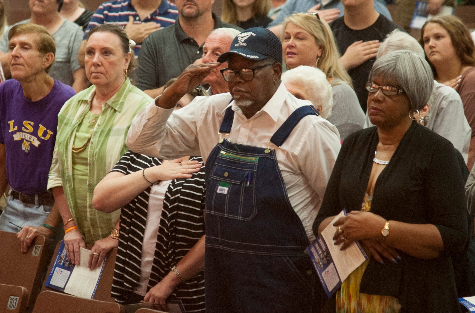 Retired Air Force Master Sgt. James D Square, who spent 24 years, 7 months as a loadmaster on C-123s, C-119s, and C-130s, salutes during the national anthem at Ponchatoula High School in Ponchatoula, Louisiana, during a show by the Airmen of Note April 26. Square is the father of the high school band director, and was sharing his Air Force story with members of the band after the show. (U.S. Air Force photo by Tech. Sgt. James Bolinger