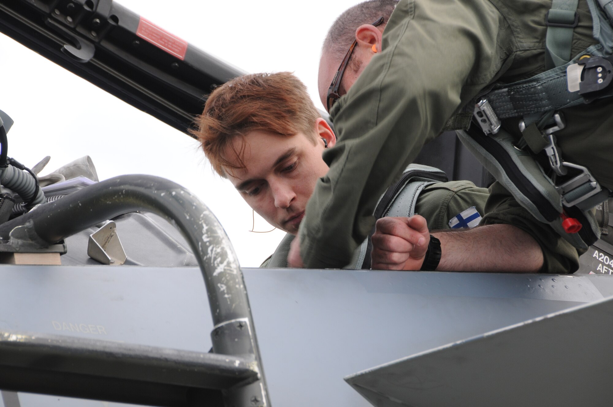 U.S. Air Force F-15 Pilot Maj. Kevin Welch, 173rd Fighter Wing Oregon Air National Guard, helps a Finnish air force F-18 pilot get situated in the back seat of an F-15 D-model, May 16, 2016, while participating in a joint exercise that is part of Operation Atlantic Resolve. During the two week exercise, Finnish and American pilots flew against each other and also escorted their counterparts in the two seat versions of both airframes. (U.S. Air National Guard photo by Tech. Sgt. Jefferson Thompson/released)