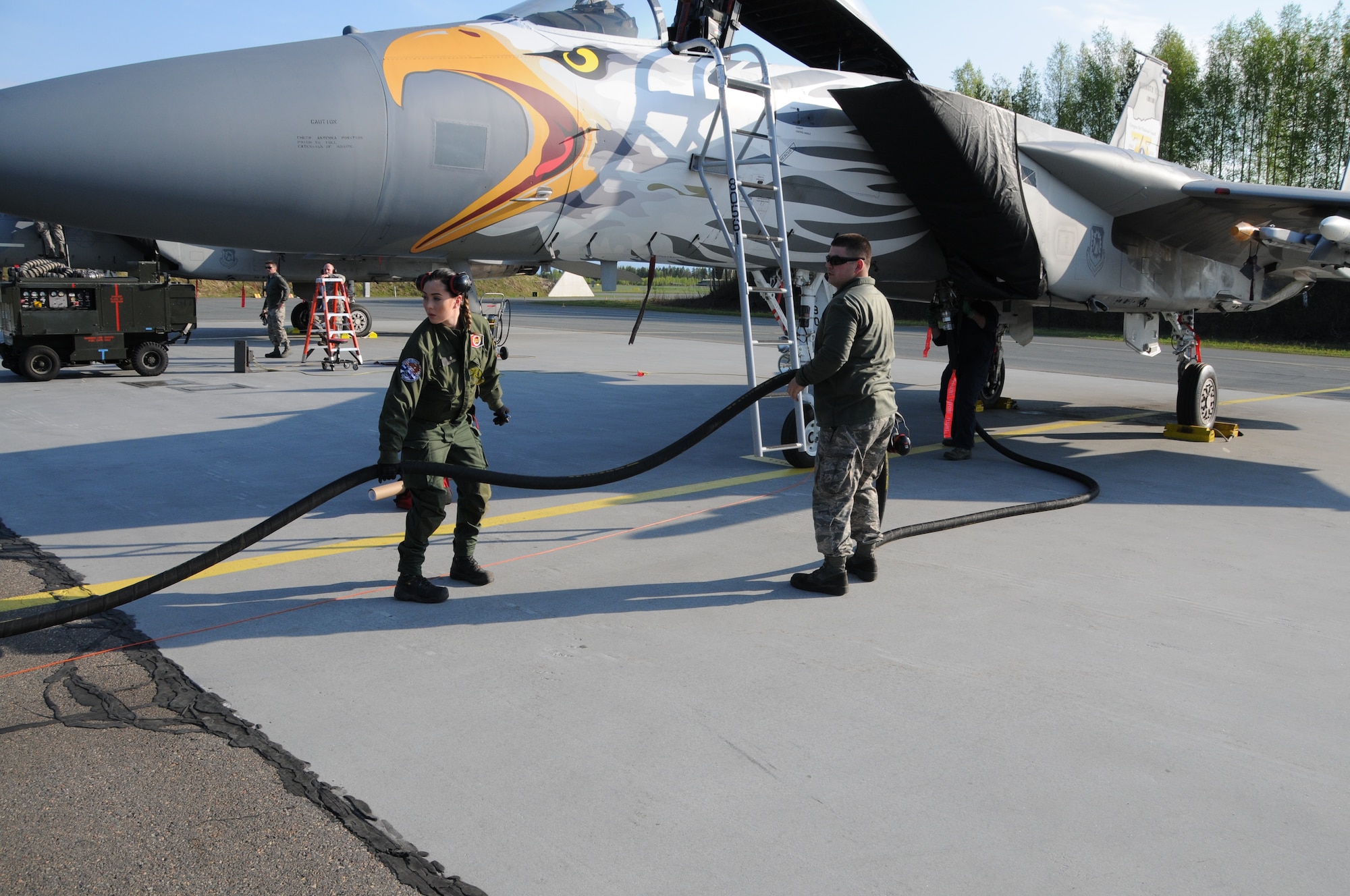 U.S. Air Force Airman 1st Class Carlos Ruiz, a 173rd Fighter Wing F-15C crew chief, works with Vilma Niiranen of the Finnish air force to fuel an F-15 following a sortie, May 10, 2016 at Rissala AFB, Finland. The aircraft sports a special paint scheme approved for one year in commemoration of the 75th Anniversary of the Oregon Air National Guard. (U.S. Air National Guard photo by Tech. Sgt. Jefferson Thompson/released)