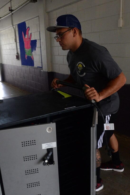 Airman 1st Class Christopher Avila, 36th Logistics Readiness Squadron fuels distributor, pushes a locker into a classroom in preparation for the 12th Festival of the Pacific Arts May 18, 2016, at George Washington High School, Mangilao, Guam.  More than 40 Airmen supported the volunteer effort to prepare schools for the two-week event that brings more than 25 Pacific island nations together to celebrate and preserve cultural art forms. (U.S. Air Force photo by Airman 1st Class Alexa Ann Henderson)