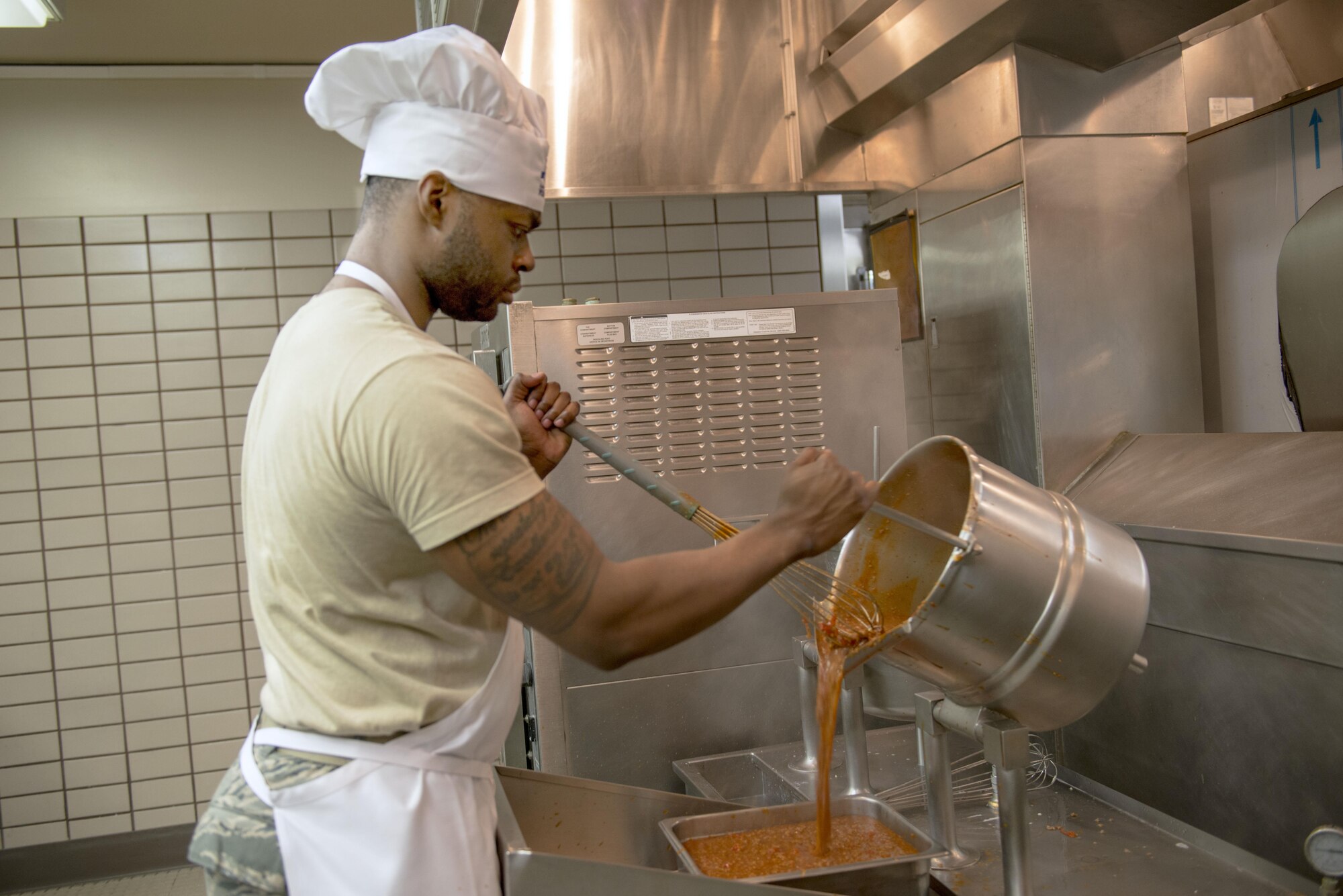 U.S. Air Force Staff Sgt. Jeanpaul Williams, a 168th Force Support Squadron services craftsman, mixes sauce for spaghetti, May 11, 2016, at Eielson Air Force Base, Alaska. The normally 21-day menu was condensed down to 14 to accommodate for the large amount of food the workers had to prepare during RED FLAG-Alaska 16-1. (U.S. Air Force photo by Staff Sgt. Ashley Nicole Taylor/Released)