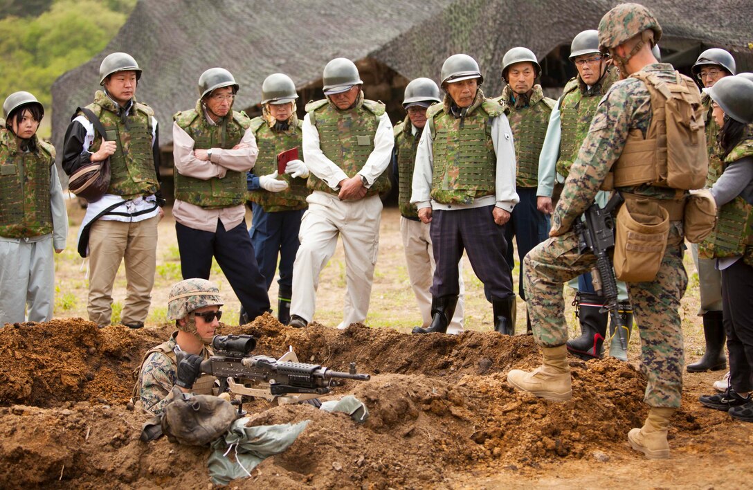Japanese citizens learn about small arms training during an artillery demonstration for Artillery Relocation Training Program 16-1, in Senjogahara, Japan, May 16, 2016. ARTP is a Japan-funded, routine training exercise that allows Marines with 3rd Battalion, 12th Marine Regiment, 3rd Marine Division, III Marine Expeditionary Force, based out of Camp Hansen, Okinawa, Japan, to conduct live-fire training. Japanese locals and media are escorted around the training area during the event to witness the measures the Marine Corps takes to conduct ARTP safely.