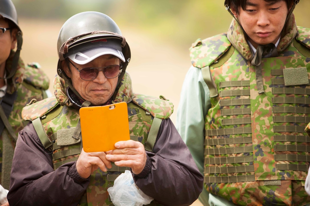 A Japanese citizen snaps a photograph during an artillery demonstration for Artillery Relocation Training Program 16-1, in Senjogahara, Japan, May 16, 2016. ARTP is a Japan-funded, routine training exercise that allows Marines with 3rd Battalion, 12th Marine Regiment, 3rd Marine Division, III Marine Expeditionary Force, based out of Camp Hansen, Okinawa, Japan, to conduct live-fire training. The artillery demonstration is a community outreach event that allows Japanese citizens and media to see how the Marine Corps trains.