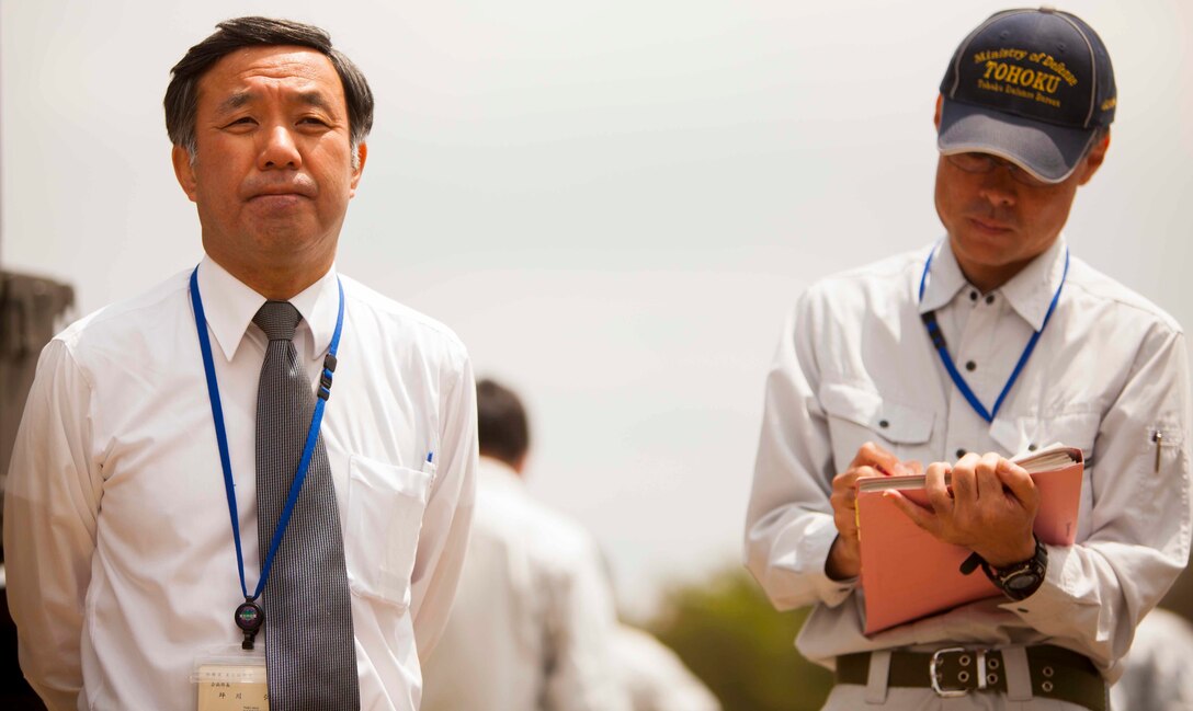 Hiroshi Tsubokawa (left), the planning department director for the Tohoku Defense Bureau, answers questions from Japanese media during an artillery demonstration for Artillery Relocation Training Program 16-1, in Senjogahara, Japan, May 16, 2016. ARTP is a Japan-funded, routine training exercise that allows Marines with 3rd Battalion, 12th Marine Regiment, 3rd Marine Division, III Marine Expeditionary Force, based out of Camp Hansen, Okinawa, Japan, to conduct live-fire training. Tsubokawa meets with Lt. Col. Neil J. Owens, the commanding officer of 3rd Bn., 12th Marines, on a daily basis to discuss various aspects of the exercise.