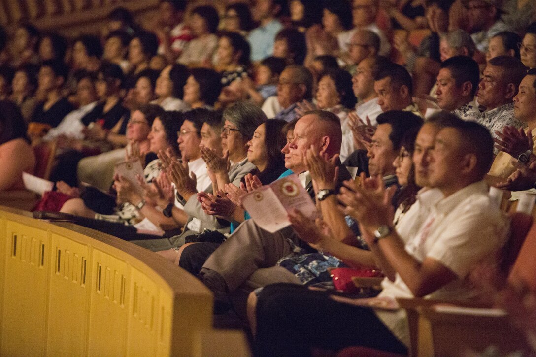 CAMP HANSEN, Okinawa, Japan – III Marine Expeditionary Force Commander Lt. Gen. Lawrence Nicholson, Ginowan City Mayor Atsushi Sakima, Ministry of Foreign Affairs Ambassador Masashi Mizukami and many other distinguished visitors applaud during the III MEF Band Spring Concert May 7, 2016 at Tedako Hall, Okinawa, Japan. The III MEF Band is the only expeditionary force band in the Marine Corps, exhibiting diverse musical capabilities and proficiency in a wide variety of settings. (U.S. Marine Corps photo by Cpl. Tiffany Edwards)
