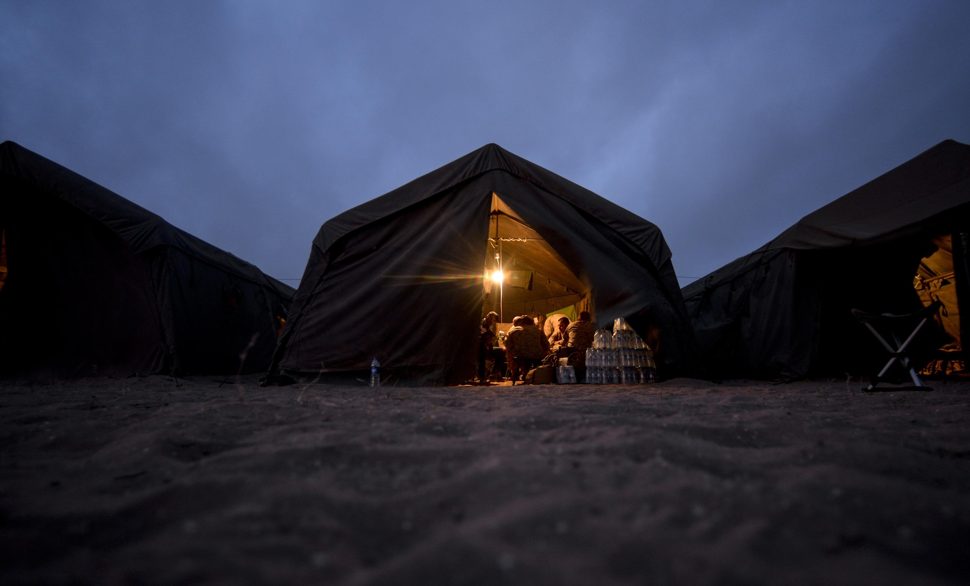 Military members participating in AFRICAN LION 16 gather inside of their tents at the end of the day at Tifnit, Kingdom of Morocco, April 23, 2016. Of the 11 nations participating in the annual exercise, a group of U.S. military members, Royal Moroccan armed forces members, Spanish Legion soldiers and Royal Netherlands army soldiers lived in field conditions and participated in daily familiarization with other nations’ tactics to improve interoperability. (U.S. Air Force photo by Senior Airman Krystal Ardrey)