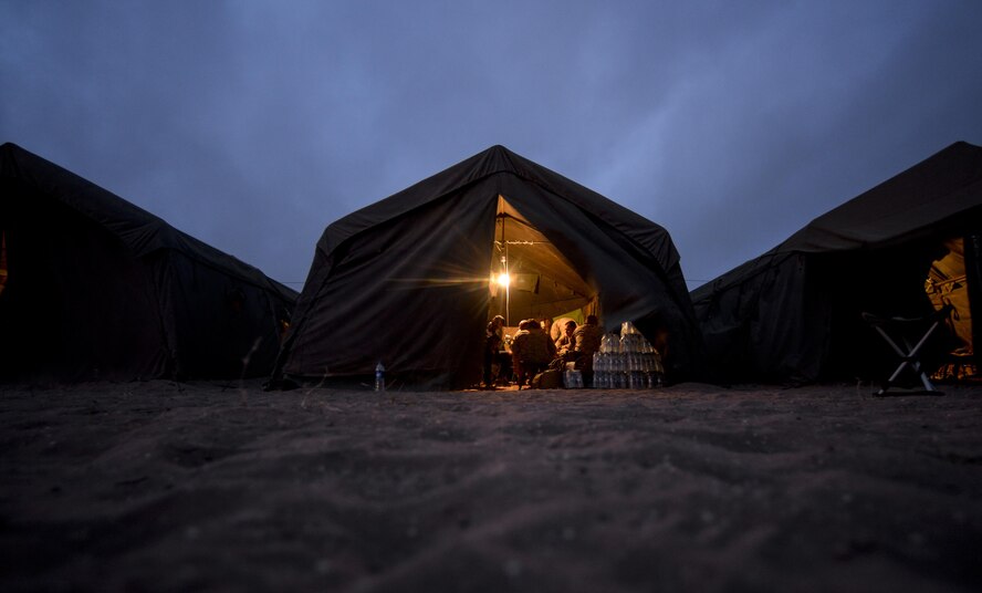 Military members participating in AFRICAN LION 16 gather inside of their tents at the end of the day at Tifnit, Kingdom of Morocco, April 23, 2016. Of the 11 nations participating in the annual exercise, a group of U.S. military members, Royal Moroccan armed forces members, Spanish Legion soldiers and Royal Netherlands army soldiers lived in field conditions and participated in daily familiarization with other nations’ tactics to improve interoperability. (U.S. Air Force photo by Senior Airman Krystal Ardrey)