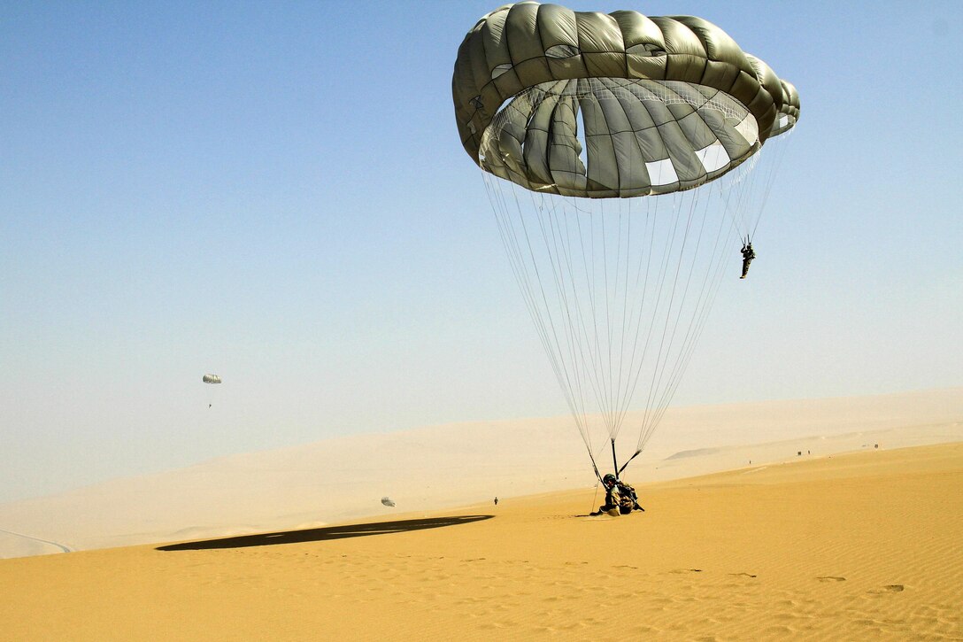 A friendship jump participant lands on sand after parachuting from a UH-60 Black Hawk helicopter during the closing event of Fuerzas Comando 2016 in Ancon, Peru, May 11, 2016. Army photo by Spc. Jaccob Hearn