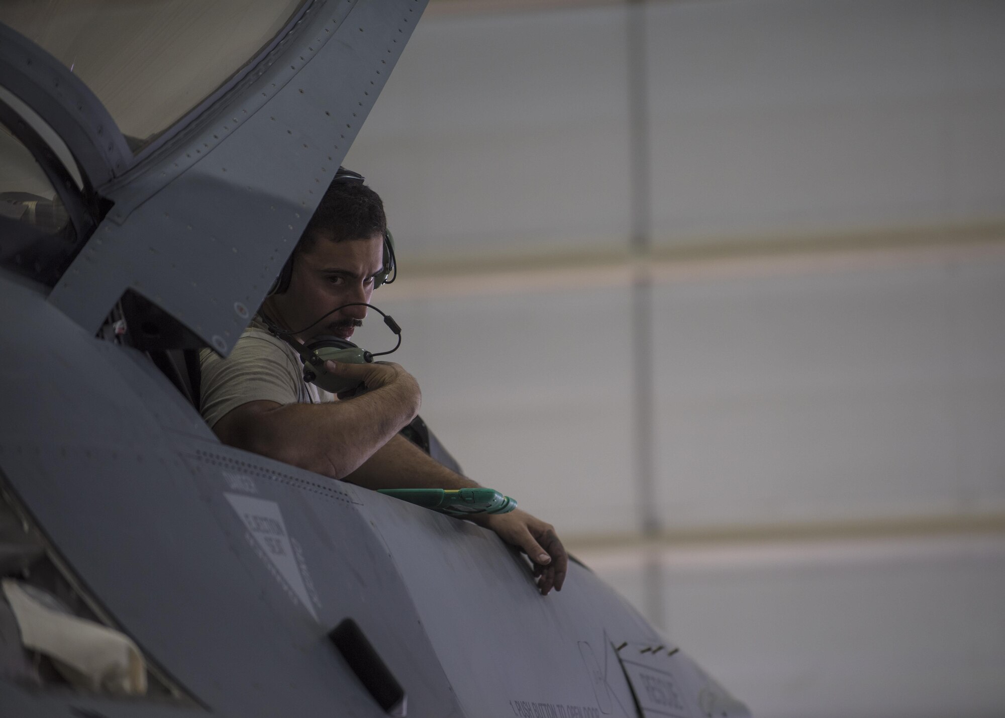 Staff Sgt. Noel Feliciano, 455th Expeditionary Aircraft Maintenance Squadron phase technician, looks back to communicate with other Airman working on an F-16C Fighting Falcon during routine phase maintenance at Bagram Airfield, Afghanistan, May 18, 2016. This aircraft is going through phase maintenance where members of the 455th EAMS phase flight closely inspect the aircraft for cracks and other types of damage, verifying that the 30 plus year old aircraft is safe to fly. (U.S. Air Force photo by Senior Airman Justyn M. Freeman)