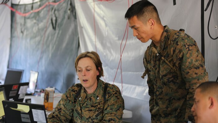 Lt. Col. Regina Gustavsson and Sgt. Peter Apiag discuss reporting requirements for their section for a simulated mishap during II Marine Expeditionary Force Exercise 16 at Marine Corps Air Station Cherry Point, N.C., May 11, 2016. MEFEX 16 is a command and control exercise conducted in a deployed environment designed to synchronize and bring to bear the full spectrum of II Marine Expeditionary Force's C2 capabilities in support of a Marine Air-Ground Task Force. 