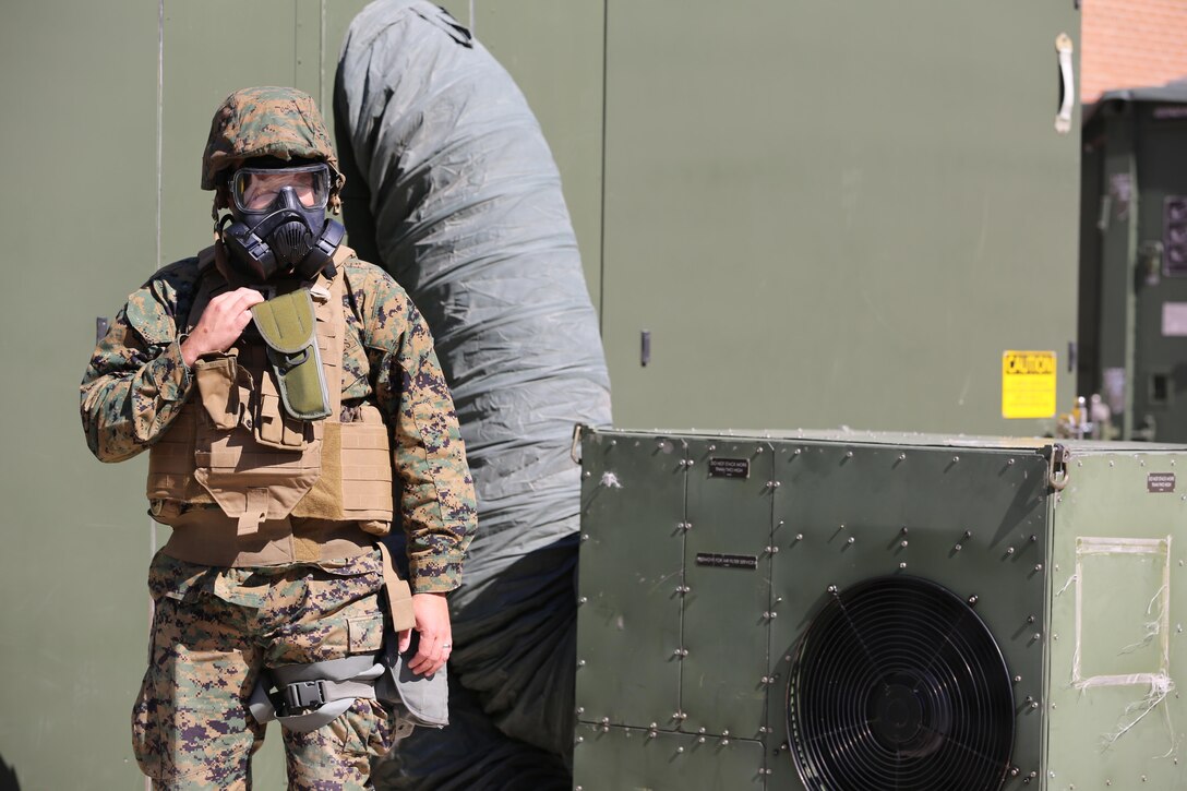 A Marine ensures others don their gas masks during a chemical, biological, radiological and nuclear defense drill as part of 2nd Marine Aircraft Wing’s portion of the Marine Expeditionary Force Exercise 2016 at Marine Corps Air Station Cherry Point, N.C., May 15, 2016. The purpose of the drill was to ensure that the Marines knew how to react quickly and use their equipment properly. MEFEX 16 is designed to synchronize and bring to bear the full spectrum of II MEF’s command and control capabilities in support of the Marine Air-Ground Task Force. (U.S. Marine Corps photo by Staff Sgt. Rebekka S. Heite/Released)