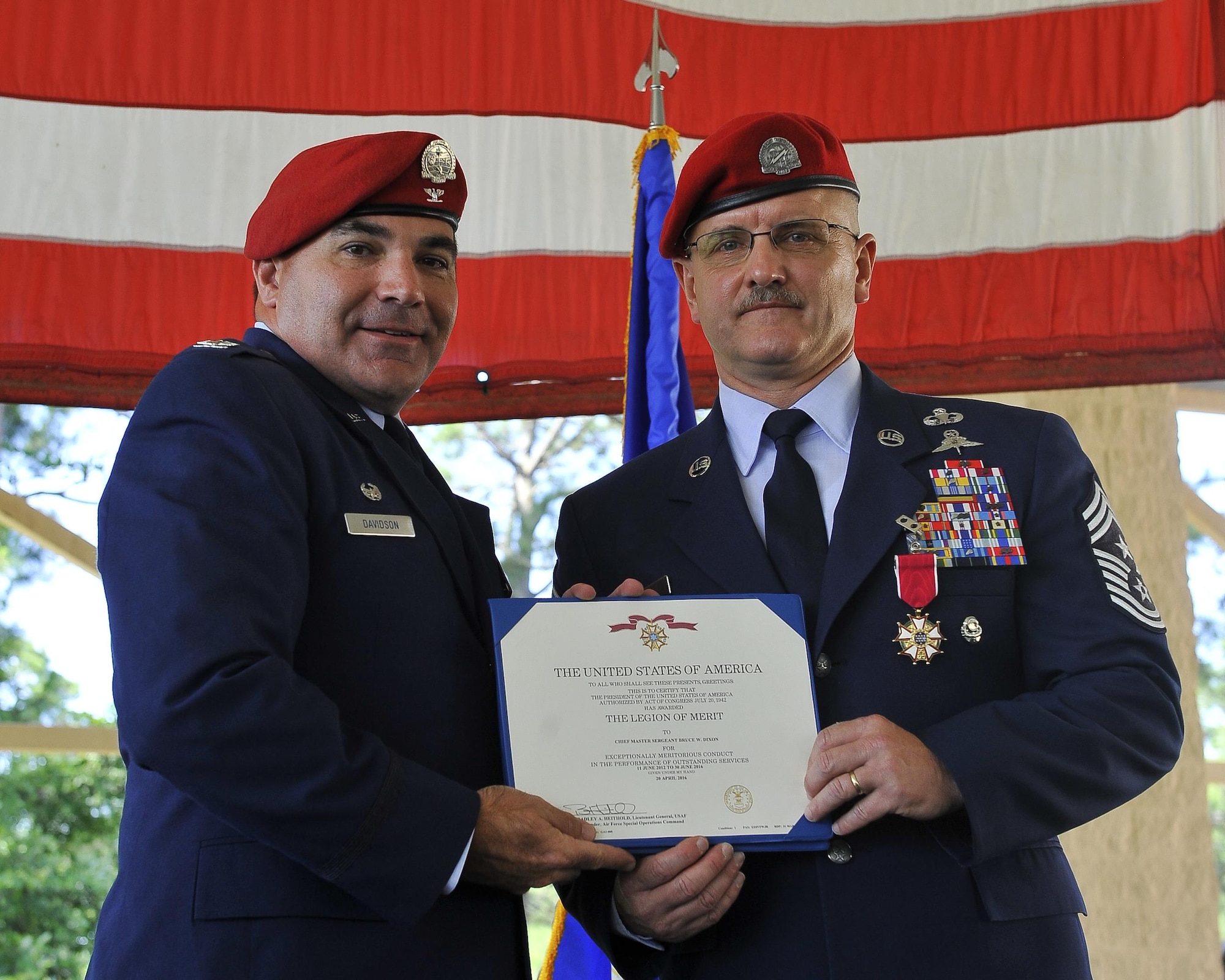 Col. Matthew Davidson, the commander of the 24th Special Operations Wing, presents Chief Master Sgt. Bruce Dixon, the command chief master sergeant of the 24th SOW, a Legion of Merit Medal certificate during Dixon's retirement ceremony at Hurlburt Field, Fla., May 13, 2016. Dixon served 30 years as a combat controller, earning the title of master parachutist with more than 400 military jumps including three combat jumps in Afghanistan. In total, he spent ten of those thirty years away from his family, consistently serving his nation's call in dangerous ground combat and training. (U.S. Air Force photo by Airman 1st Class Kai White)