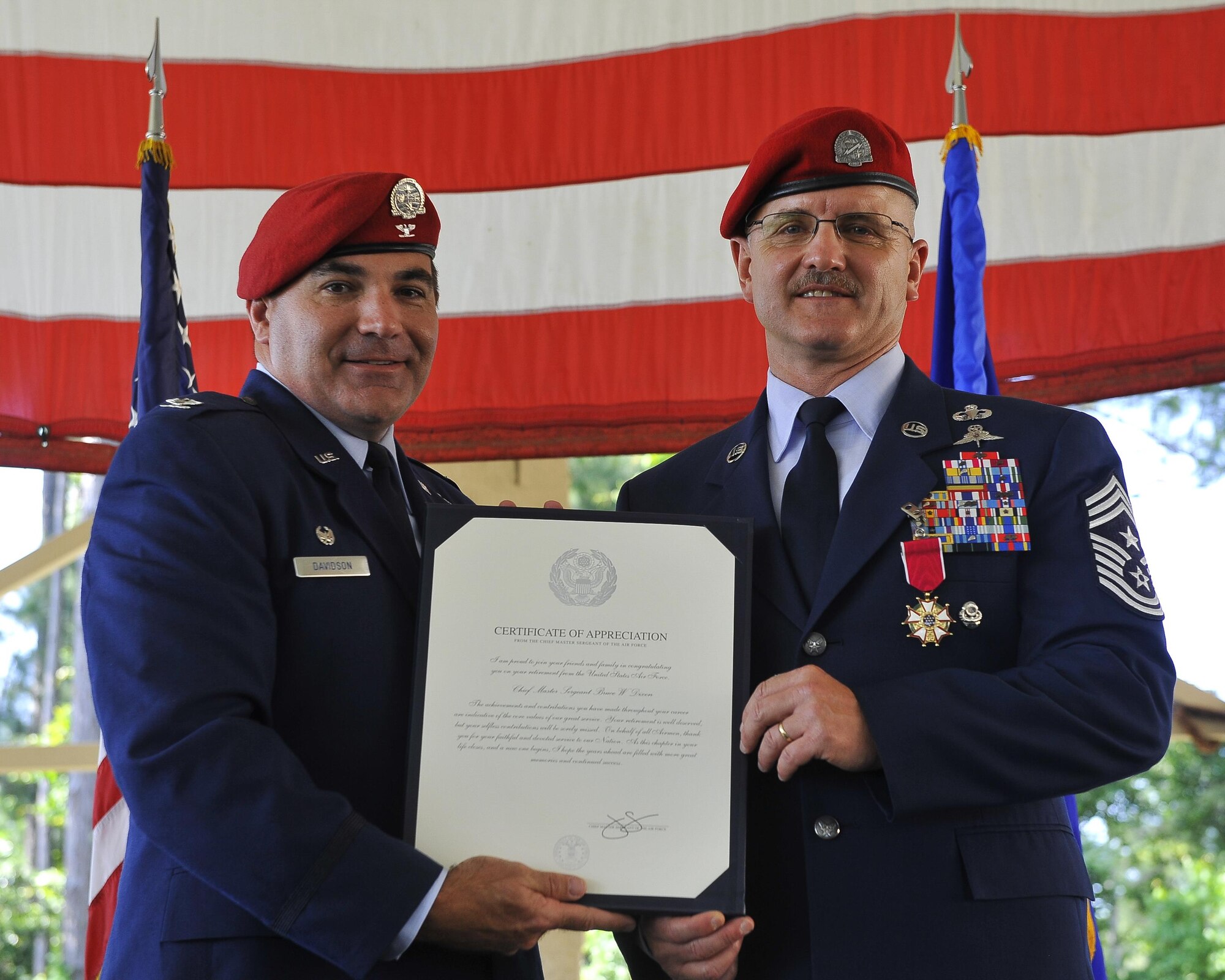 Col. Matthew Davidson, the commander of the 24th Special Operations Wing, presents Chief Master Sgt. Bruce W. Dixon, the command chief of the 24th SOW, with a certificate of retirement during Dixon's retirement ceremony at Hurlburt Field, Fla., May 13, 2016. Dixon served 30 years as a combat controller, earning the title of master parachutist with more than 400 military jumps including three combat jumps in Afghanistan. In total, he spent ten of those thirty years away from his family, consistently serving his nation's call in dangerous ground combat and training. (U.S. Air Force photo by Airman 1st Class Kai White)