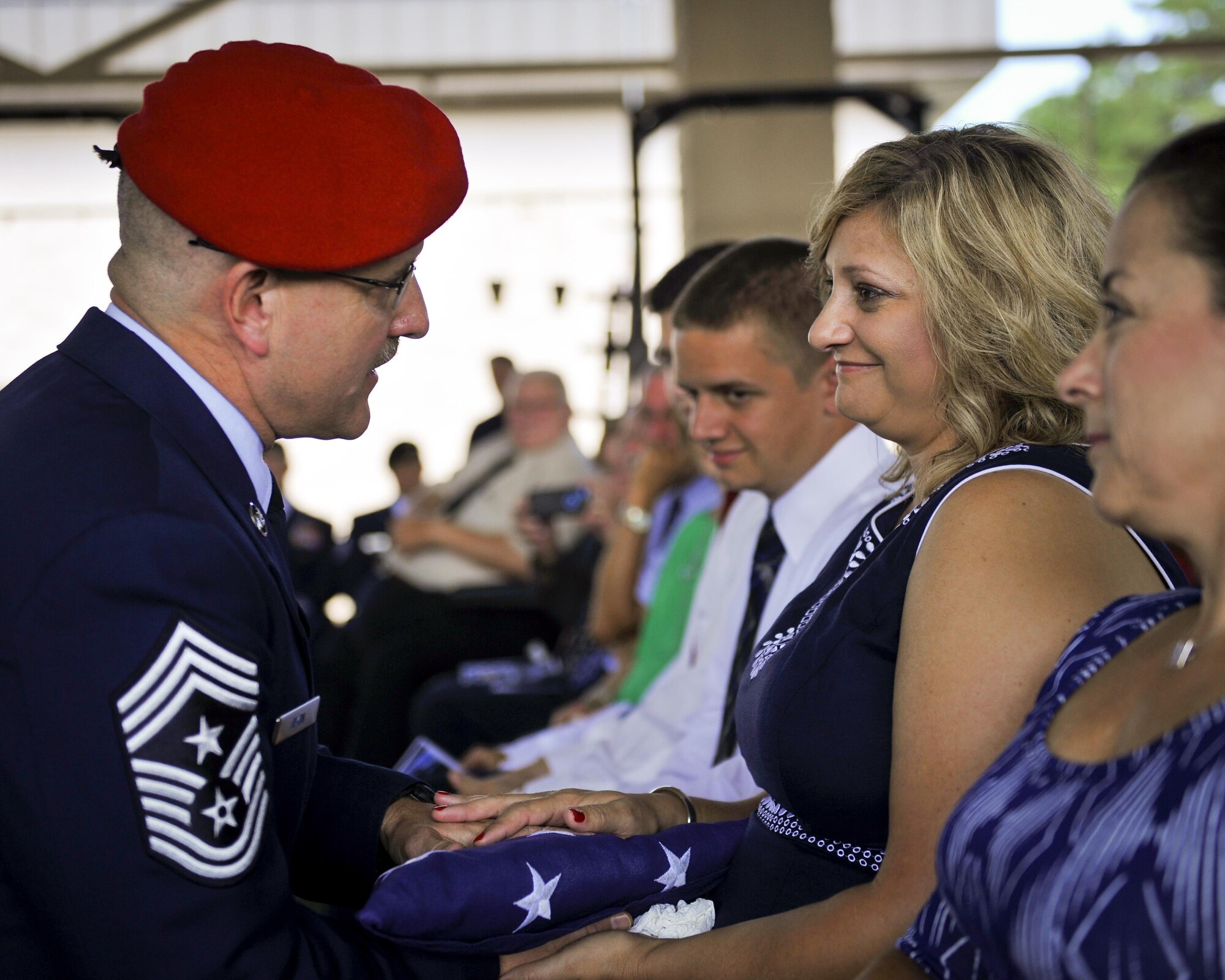 Chief Master Sgt. Bruce W. Dixon, the command chief master sergeant of the 24th Special Operations Wing, presents his wife, Lori Dixon, with an American flag at Hurlburt Field, Fla. May 13, 2016. Dixon served 30 years as a combat controller earning the title of master parachutist with more than 400 military jumps including three combat jumps in Afghanistan. In total, he spent ten of those thirty years away from his family, consistently serving his nation's call in dangerous ground combat and training. (U.S. Air Force photo by Airman 1st Class Kai White) 