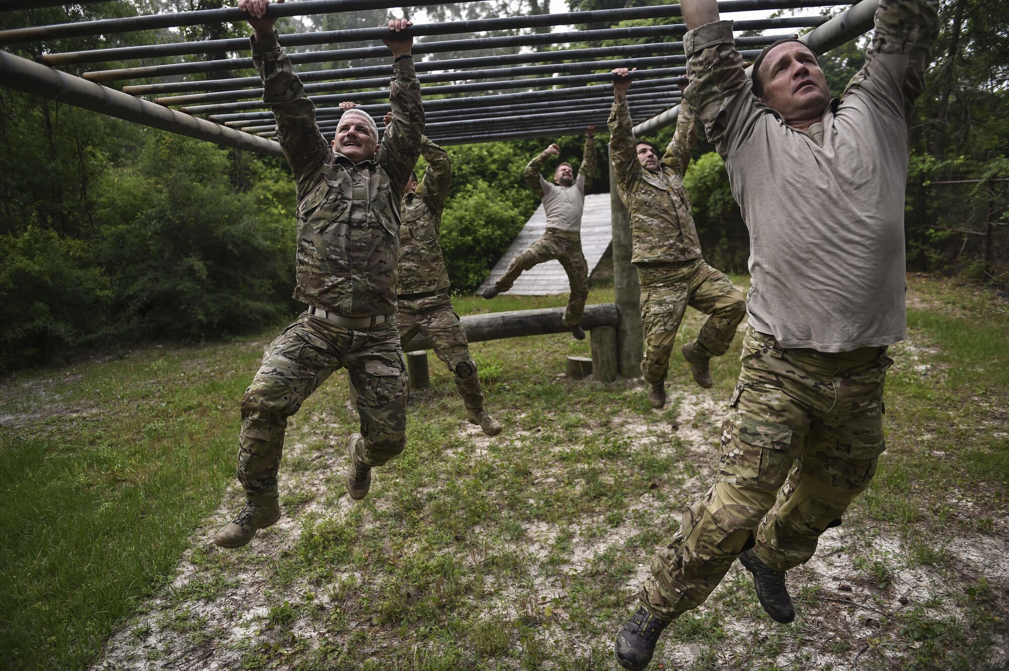 Monster Mash Team 4 completes a monkey-bar obstacle during a Monster Mash at Hurlburt Field, Fla., May 12, 2016. Monster Mash is a long-standing Special Tactics training tradition, consisting of an obstacle course where special operators complete timed scenarios at different stations of core mission training. The event was held in honor of Chief Master Sgt. Bruce W. Dixon, the command chief of the 24th Special Operations Wing, who is retiring after a 30-year career as a combat controller. (U.S. Air Force photo by Senior Airman Ryan Conroy) 
