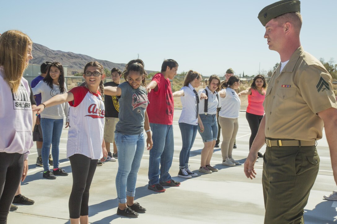 Cpl. Robert Taylor, communications specialist aboard Marine Corps Logistics Base Barstow, teaches students from the Yermo School in Yermo, Calif. how to "dress right dress" during a Drill and Ceremonies training session, May 12, 2016. The corporal and various other Barstow Marines spent the afternoon teaching the Yermo students the basics of marching, saluting, and military bearing during their Civil War Days event. 
