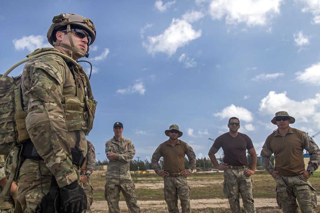 A U.S. sailor, left, explains counter Improvised Explosive Device methods with members of the New Zealand navy operational diving team during an IED training scenario as part of Exercise Tricrab at Naval Base Guam, May 09, 2016. The sailor is an explosive ordnance disposal technician assigned to Explosive Ordnance Disposal Mobile Unit 5. Tricrab, a combined exercise involving military forces from five different countries, focuses on strengthening relationships within the Asia-Pacific region. Navy photo by Petty Officer 3rd Class Alfred A. Coffield