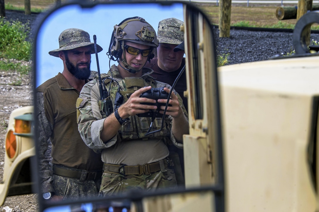 A U.S. sailor, right, shows members of the New Zealand navy operational diving team how to operate an Unmanned Ground Vehicle during an Improvised Explosive Device scenario as part of Exercise Tricrab at Naval Base Guam, May 09, 2016. Navy photo by Petty Officer 3rd Class Alfred A. Coffield