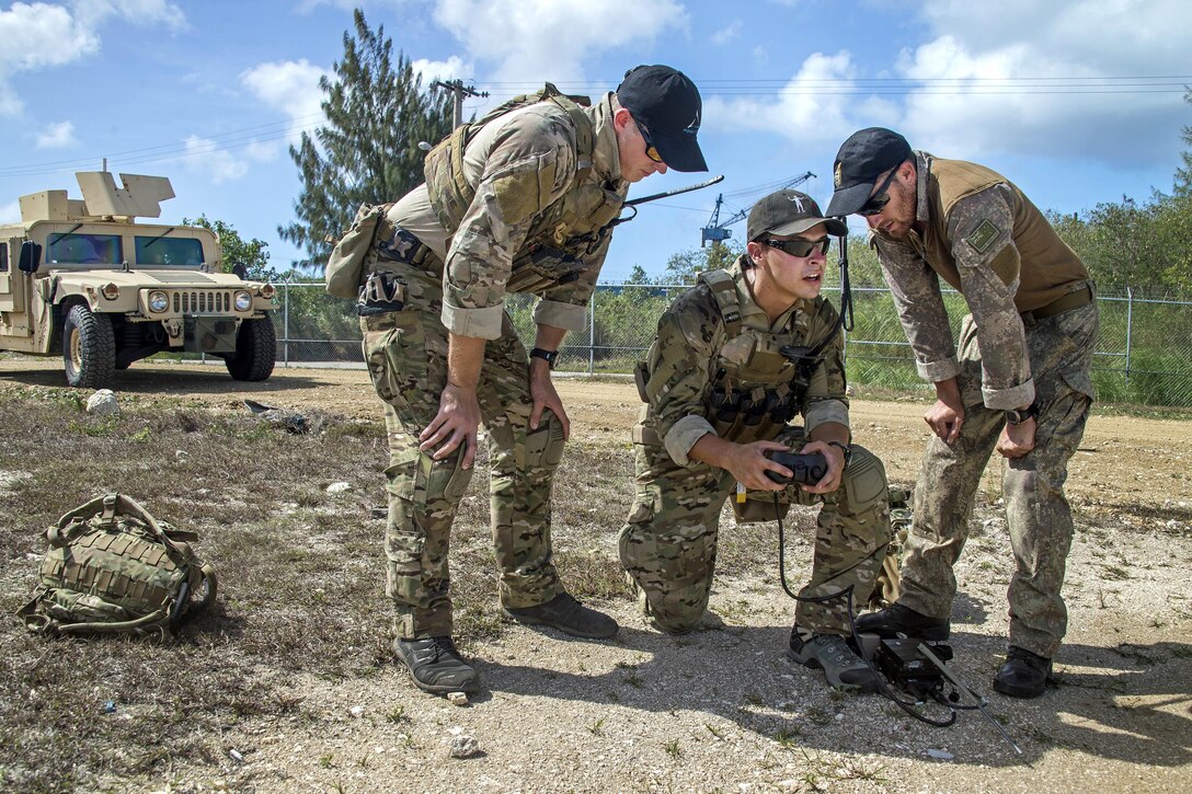 A U.S. sailors, center, operates an unmanned ground vehicle as members of the New Zealand navy operational diving team look on during Exercise Tricrab at Naval Base Guam, May 09, 2016. Navy photo by Petty Officer 3rd Class Alfred A. Coffield 