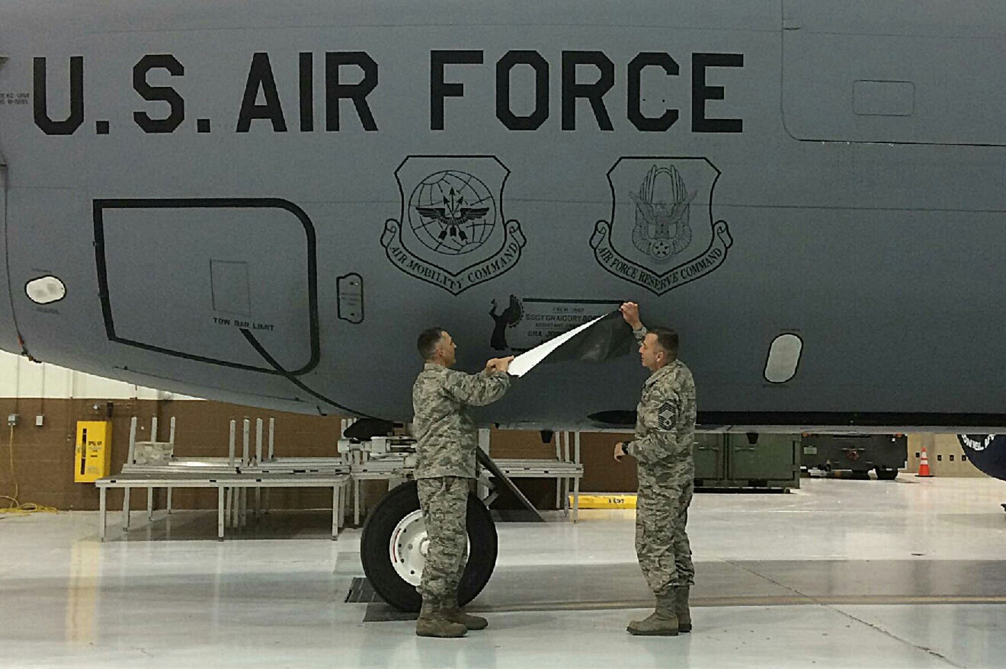 Lt. Col. Duane Richardson, the 22nd Aircraft Maintenance Squadron commander, left, and Chief Master Sgt. Joseph Thomas, the 22nd AMXS superintendent, reveal the dedicated crew chief box on a KC-135 Stratotanker May 2, 2016, at McConnell Air Force Base, Kan. The 22nd AMXS and the 931st Aircraft Maintenance Squadron held a DCC induction ceremony where 58 DCCs and assistant DCCs were assigned to 25 KC-135 Stratotankers. (Courtesy photo)