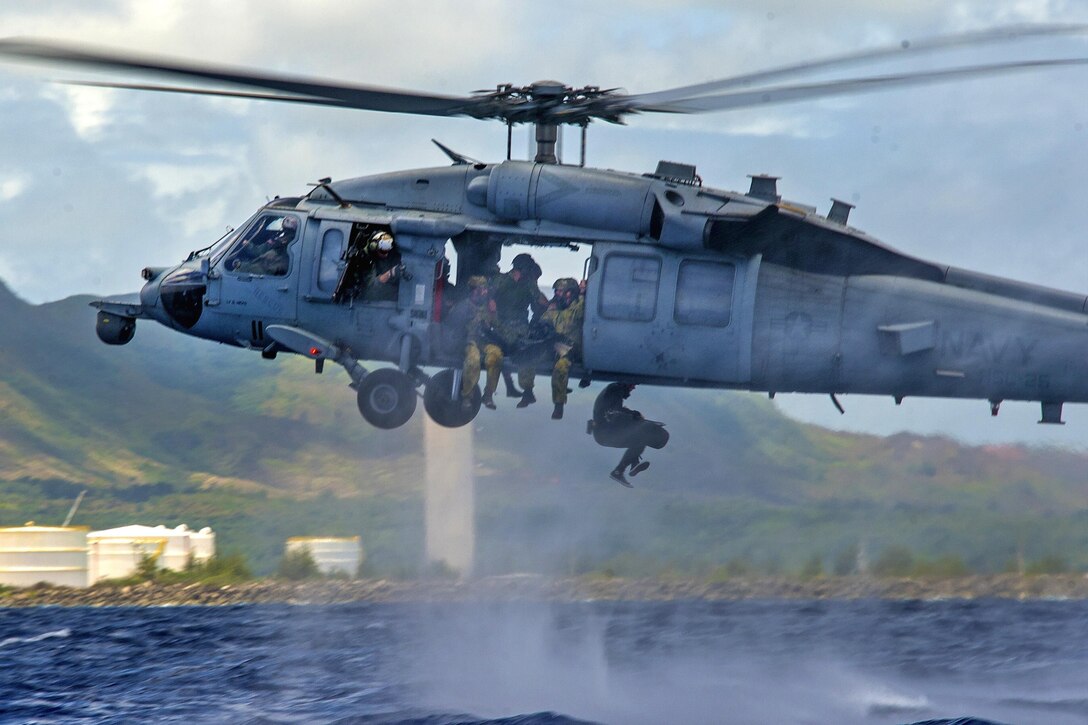 U.S. Navy Petty Officer 1st Class Doug Harvey, left, takes photographs of U.S. sailors, and Australian navy clearance divers from a MH-60S Seahawk helicopter during Exercise Tricrab off the coast of Guam, May 10, 2016. Harvey is a mass communications specialist. Navy photo by Petty Officer 3rd Class Alfred A. Coffield