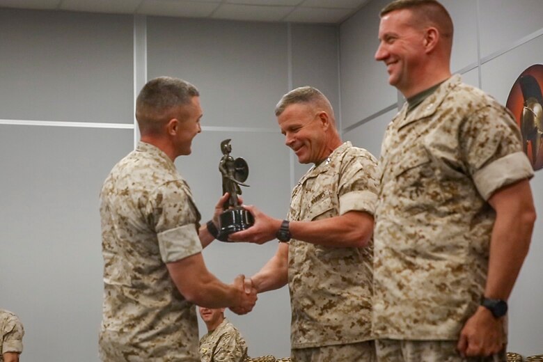 Maj. Gen. Lewis A. Craparotta, Combat Center Commanding General, presents one of four honor graduates a trophy during the graduation ceremony for Tactical Marine Air Ground Task Force Integration Course 1-16 aboard the Combat Center May 6, 2016. (Official Marine Corps photo by Lance Cpl. Levi Schultz/Released)