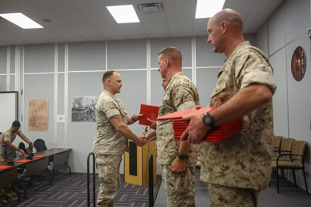 Maj. Gen. Lewis A. Craparotta, Combat Center Commanding General, congratulates a graduate during the graduation ceremony for Tactical Marine Air Ground Task Force Integration Course 1-16 aboard the Combat Center May 6, 2016. (Official Marine Corps photo by Lance Cpl. Levi Schultz/Released)