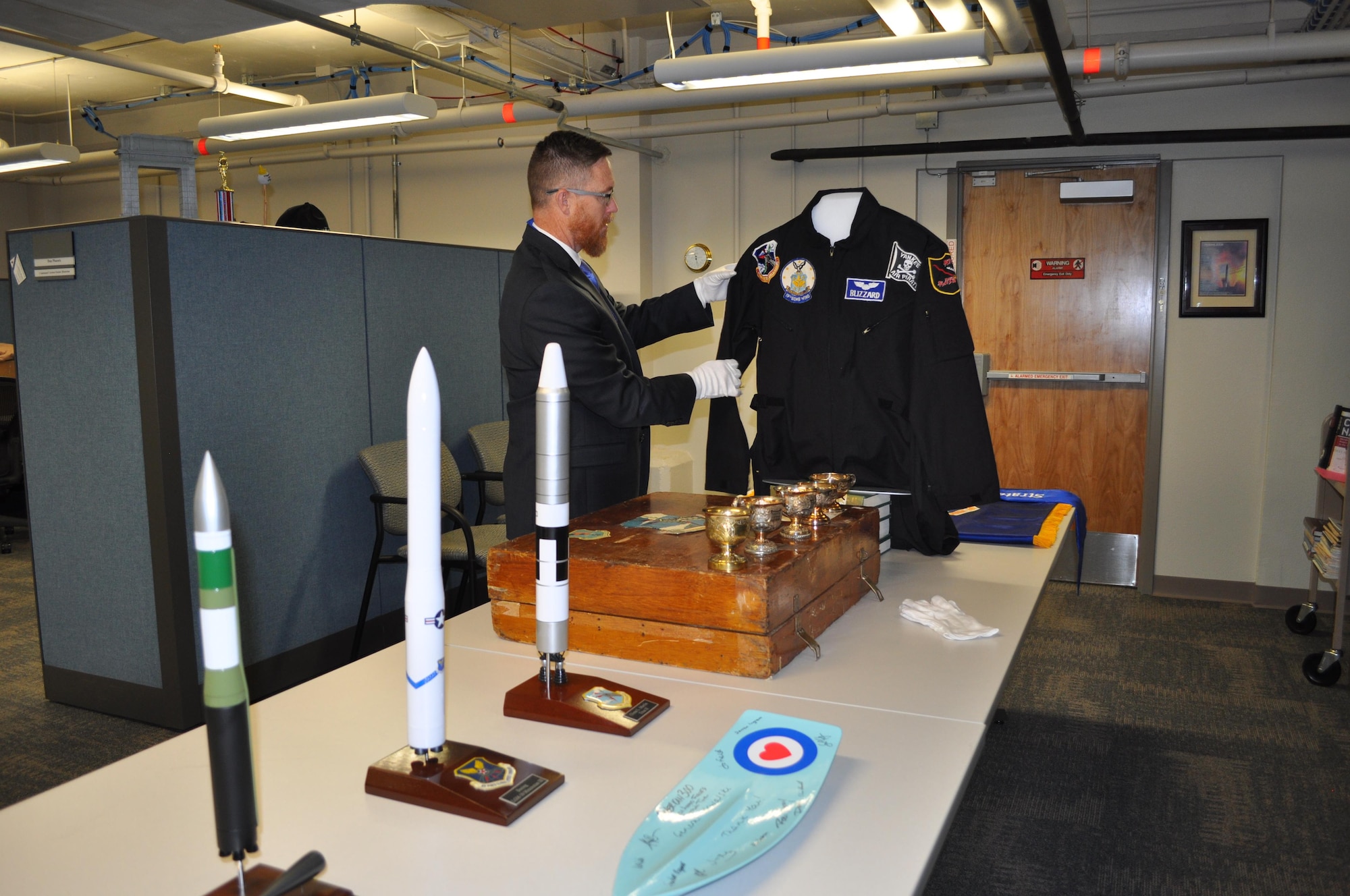 Various heritage pieces are stored in the new Global Strike Research Facility. AFGSC Command Historian Yancy Mailes, displayed many of these pieces shortly after the ribbon-cutting ceremony. Staff can check these items out for command events (Air Force Photo by TSgt. Ave Young, Air Force Global Strike Command Public Affairs).