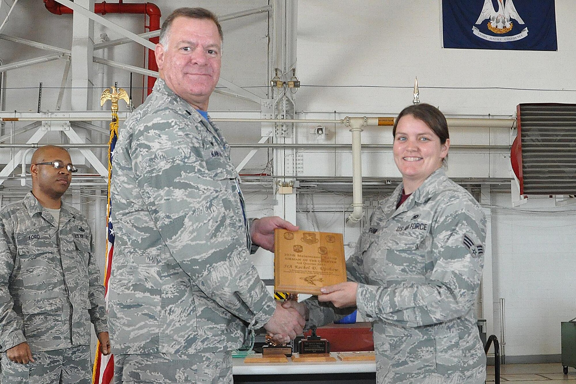 U.S. Air Force Lt. Col. Leo Kamphaus, 307th Maintenance Group (MXG) commander, presents an award to Senior Airman Rachel Upshaw during a Commander’s Call on May 15, 2016, Barksdale Air Force Base, La. Upshaw is assigned to the 707th Maintenance Squadron and was selected as the 307th MXG Airman of the Quarter for the third quarter of 2015. (U.S. Air Force photo by Master Sgt. Greg Steele/Released)