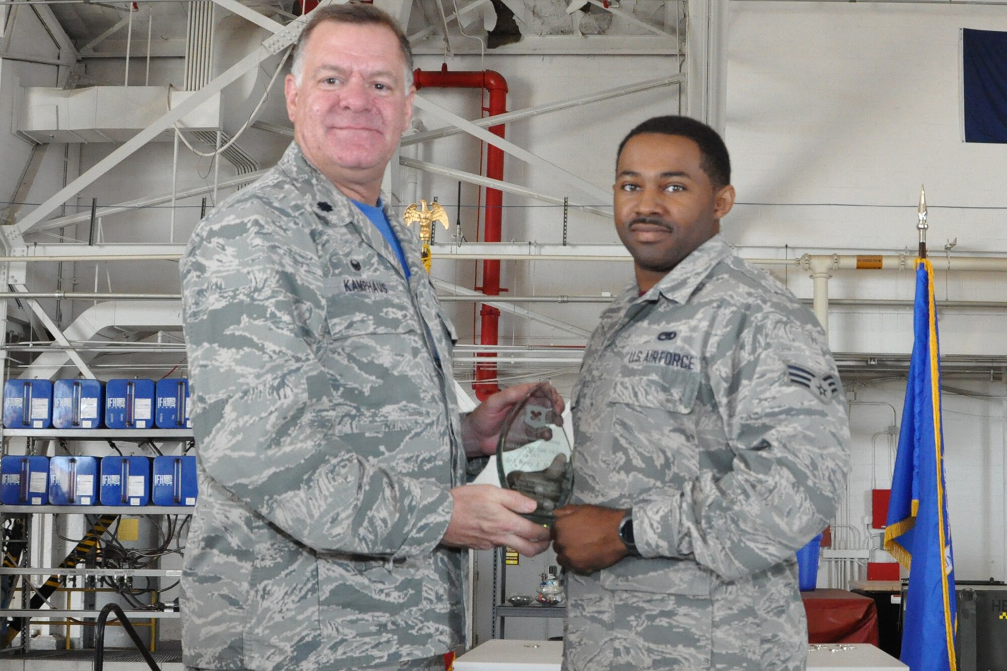 U.S. Air Force Lt. Col. Leo Kamphaus, 307th Maintenance Group commander, presents an award to Senior Airman Torry Holland during a Commander’s Call on May 15, 2016, Barksdale Air Force Base, La. Holland is assigned to the 707th Maintenance Squadron and was selected as the 307th MXG Airman of the Year for 2015. (U.S. Air Force photo by Master Sgt. Greg Steele/Released)