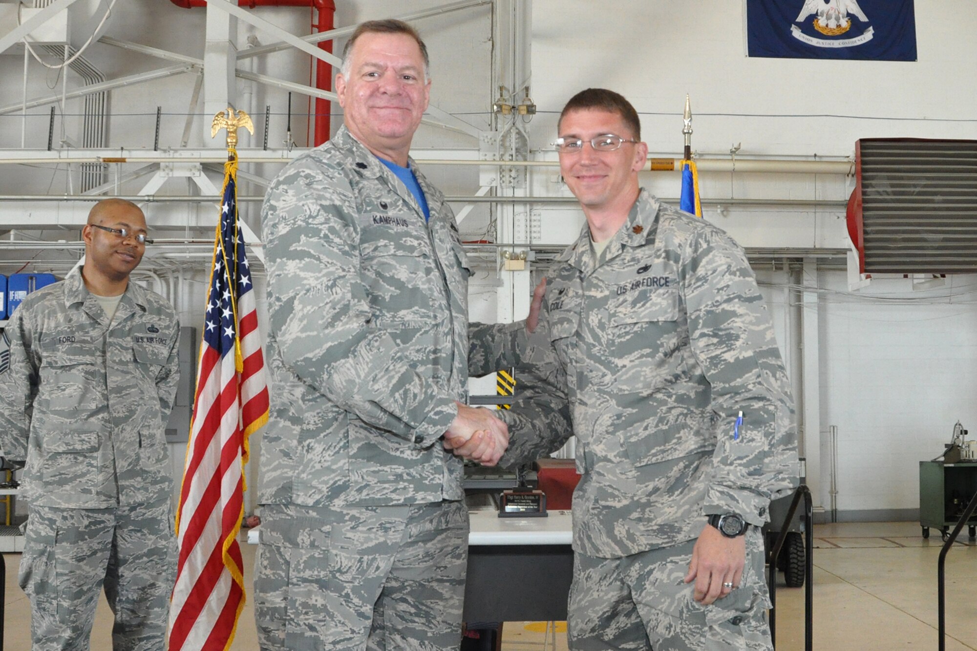U.S. Air Force Lt. Col. Leo Kamphaus, 307th Maintenance Group commander, congratulates Maj. George Cole, 307th Maintenance Squadron commander, during a Commander’s Call on May 15, 2016, Barksdale Air Force Base, La. Cole accepted the congratulations on behalf of his squadron, which was awarded the 307th Bomb Wing’s Verne Orr Award for most effectively using its resources to accomplish the Air Force mission. (U.S. Air Force photo by Master Sgt. Greg Steele/Released)