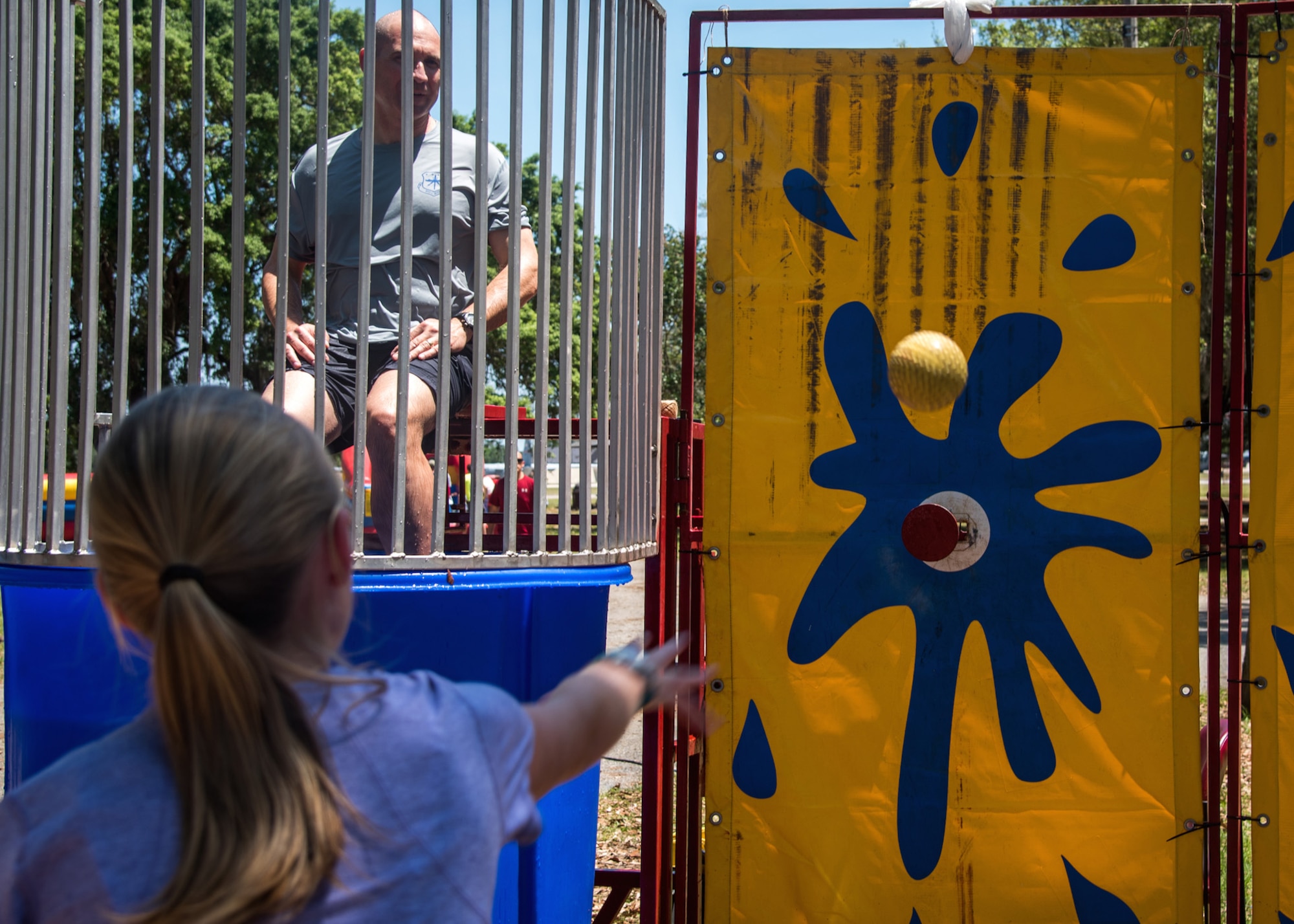 A child tries to dunk Col. Michael Manion, 403rd Wing vice commander, in the dunking booth during the Wing Spring Fling at Keesler Air Force Base, Mississippi, May 15, 2016. The purpose of the event is to allow leadership, Citizen Airmen, and their families a chance to interact and build camaraderie outside the work place. (U.S. Air Force photo/Staff Sgt. Shelton Sherrill)