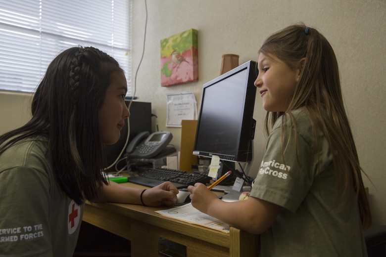 Marisol Gold, 11, chairwoman, American Red Cross Youth Club, helps Hollie Medina, 7, club member, with her homework during the ARYC’s Homework Helper Club at the Village Center May 5, 2016. The Homework Helper Club provides students with a supportive learning environment every Thursday at 5 p.m. (Official Marine Corps photo by Cpl. Connor Hancock/Released)