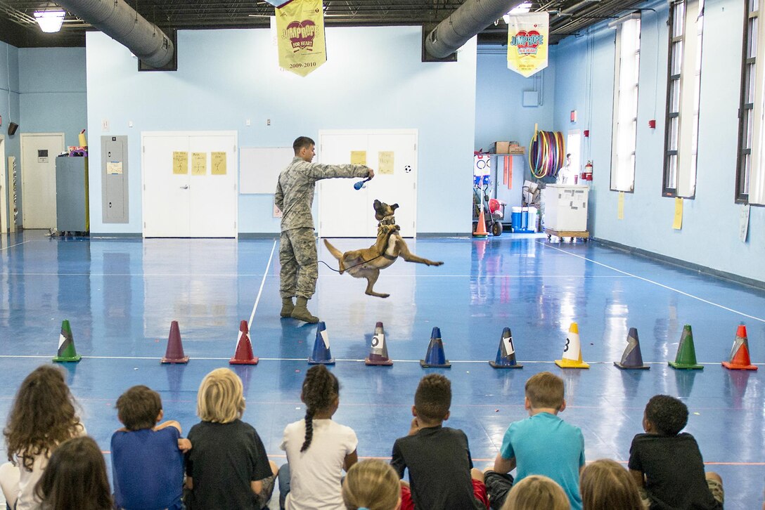 Air Force Senior Airman Chase Shankle gives a demonstration with Arko, a military working dog, for Eglin Elementary School students at Eglin Air Force Base, Fla., May 17, 2016. More than 100 children watched two military working dog teams perform during the event. Air Force photo by Samuel King Jr.
