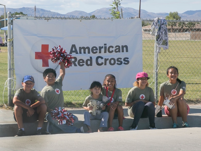 The American Red Cross Youth Club promotes their yard and bake sale at the Lincoln Military Housing athletic field May 7, 2016. The club, run by student members, holds charity events to show members the importance of giving back to the community. Fifty-five percent of the proceeds from each event go toward charity and the remaining is donated to the American Red Cross.  (Official Marine Corps photo by Cpl. Thomas Mudd/Released)