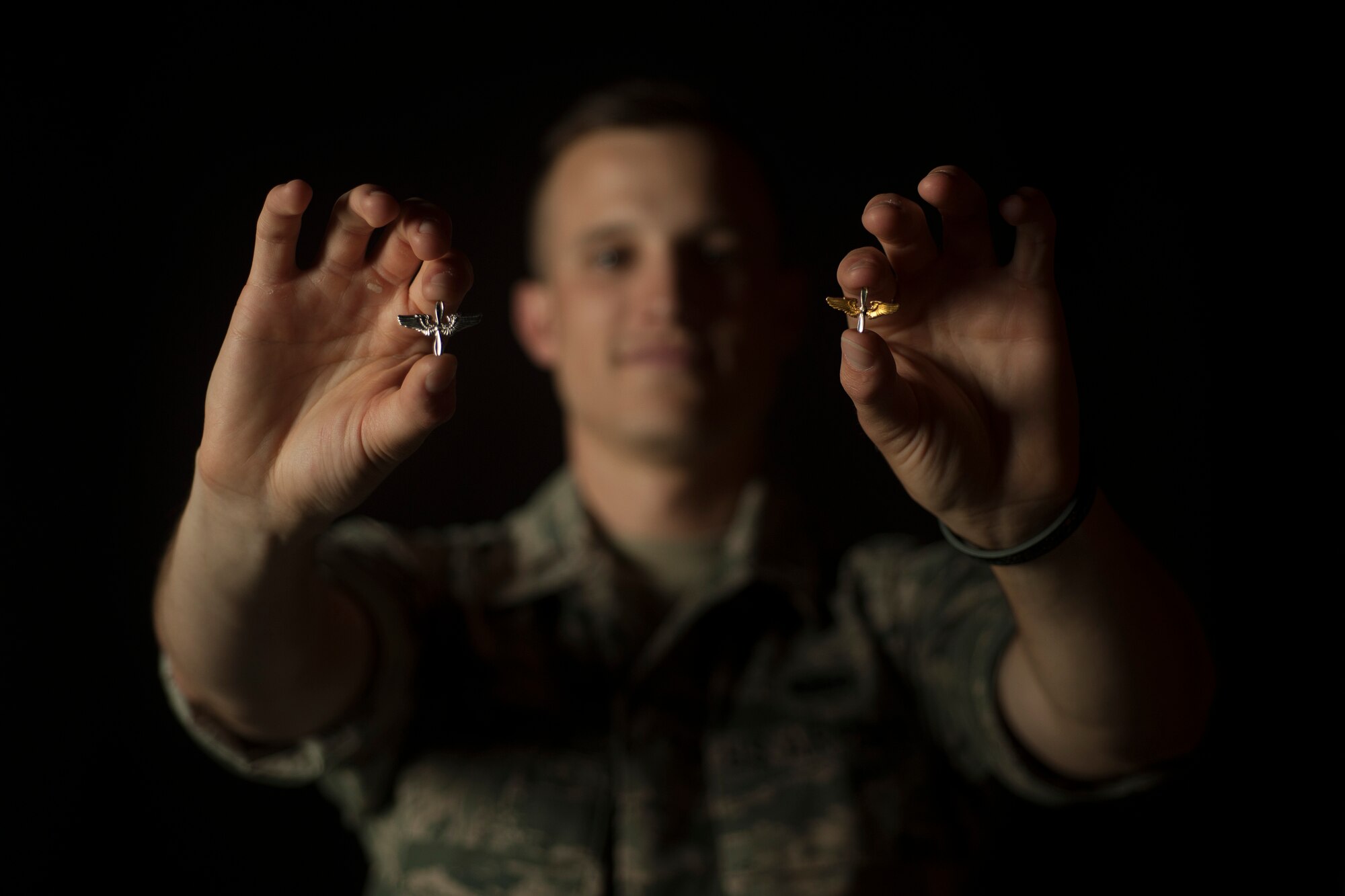 2nd Lt. William Collette, 30th Space Wing public affairs officer, holds up his set of field training prop and wings (left) along with the set he received from WWII bomber pilot Noah Thompson, May 12, 2016, Vandenberg Air Force Base, Calif.